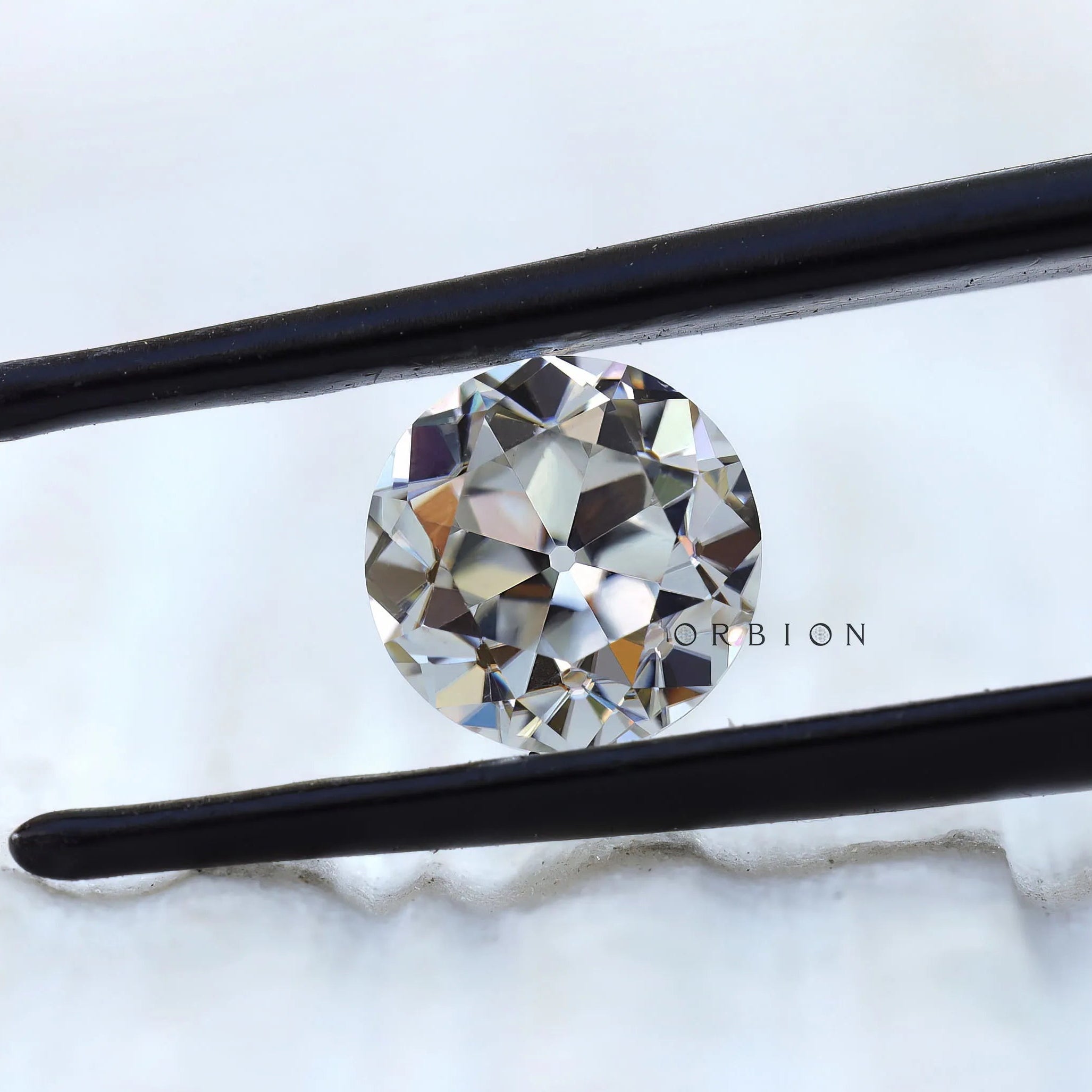 Vintage round moissanite with large facets in close view