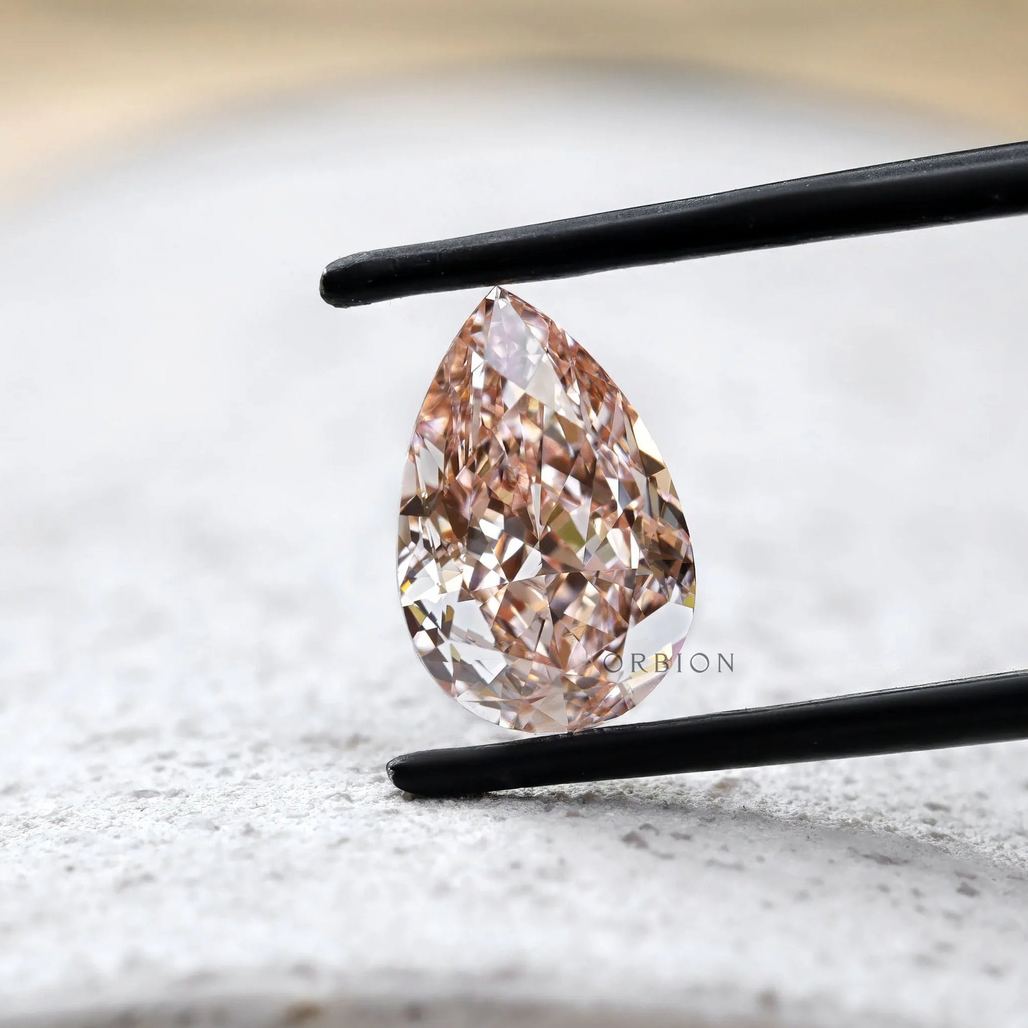 Fancy vivid pink pear diamond on light stone surface