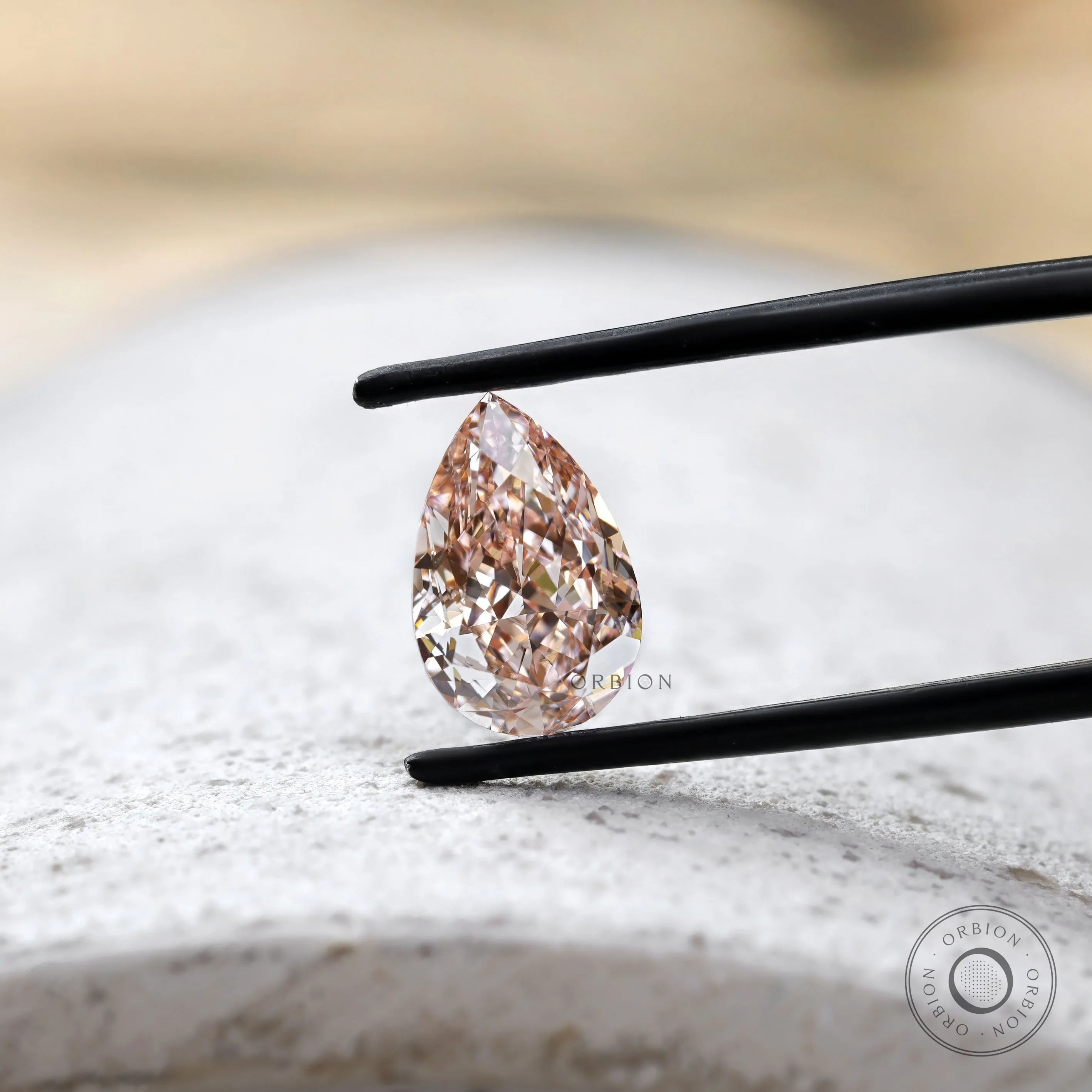 Fancy vivid pink pear diamond on light stone surface