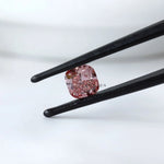 Front angled view of deep purplish pink cushion diamond