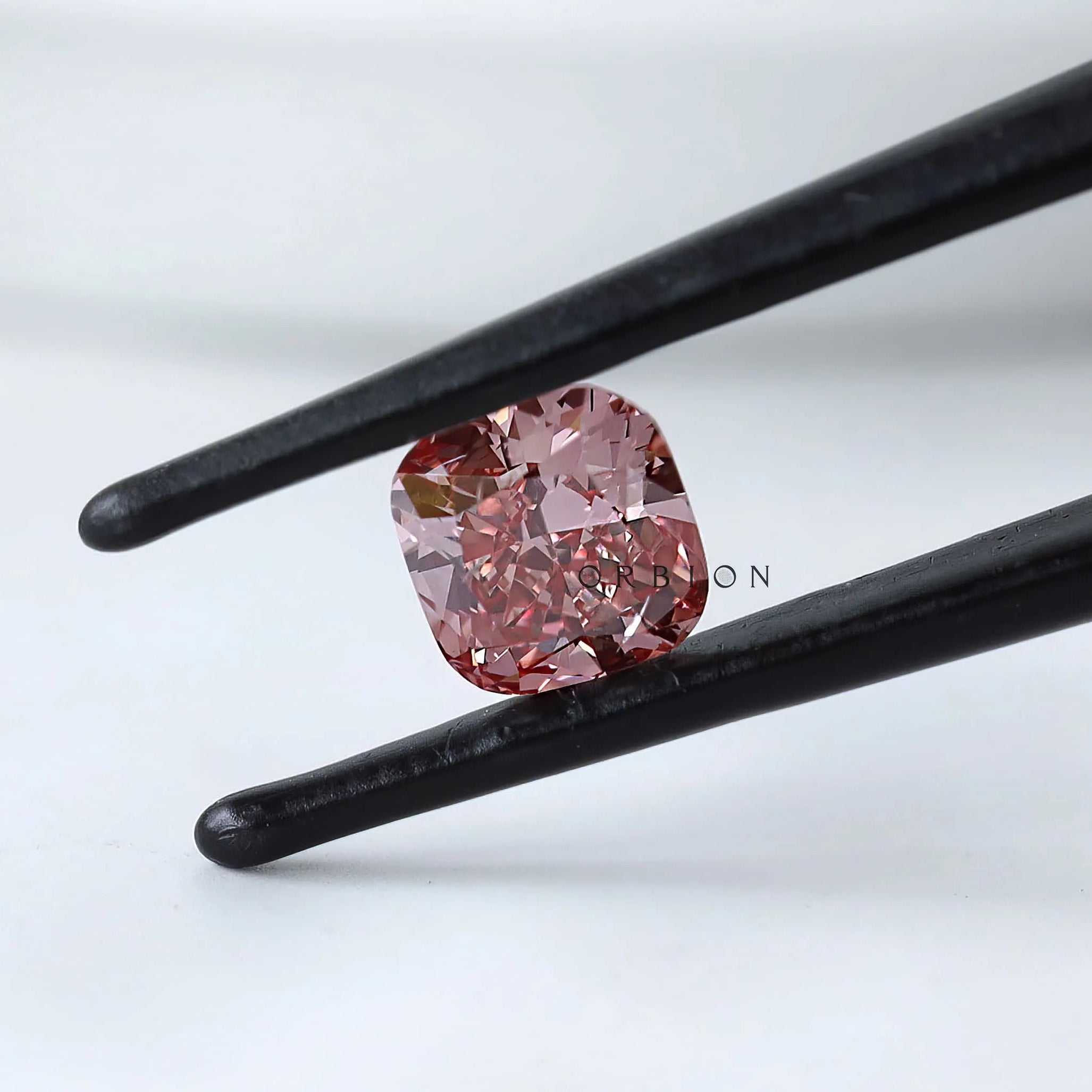 Front angled view of deep purplish pink cushion diamond