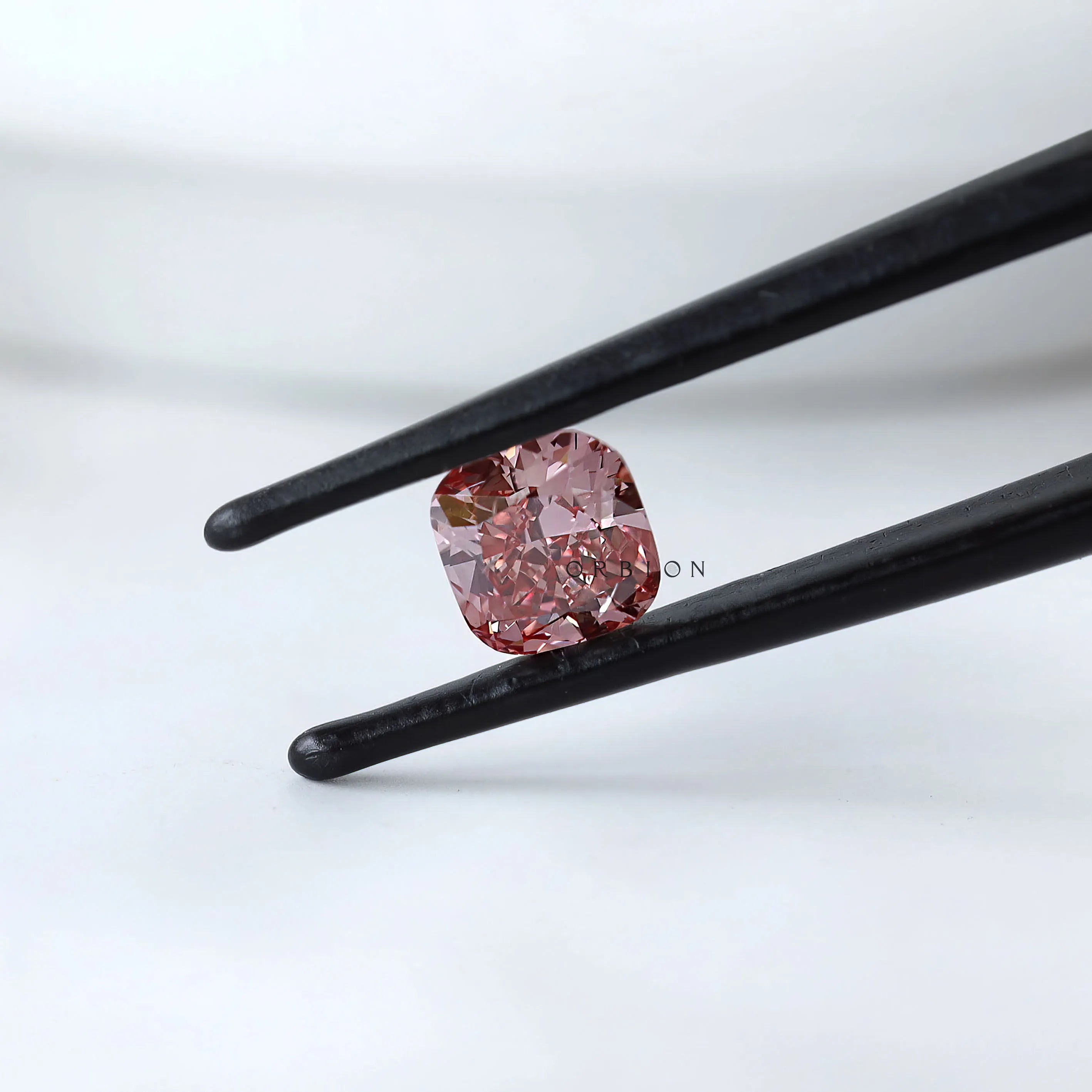 Front angled view of deep purplish pink cushion diamond