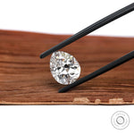 Pear shaped DEF lab diamond angled on warm wood background