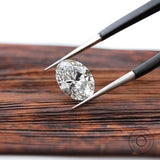 Loose oval brilliant lab diamond displayed over wooden surface