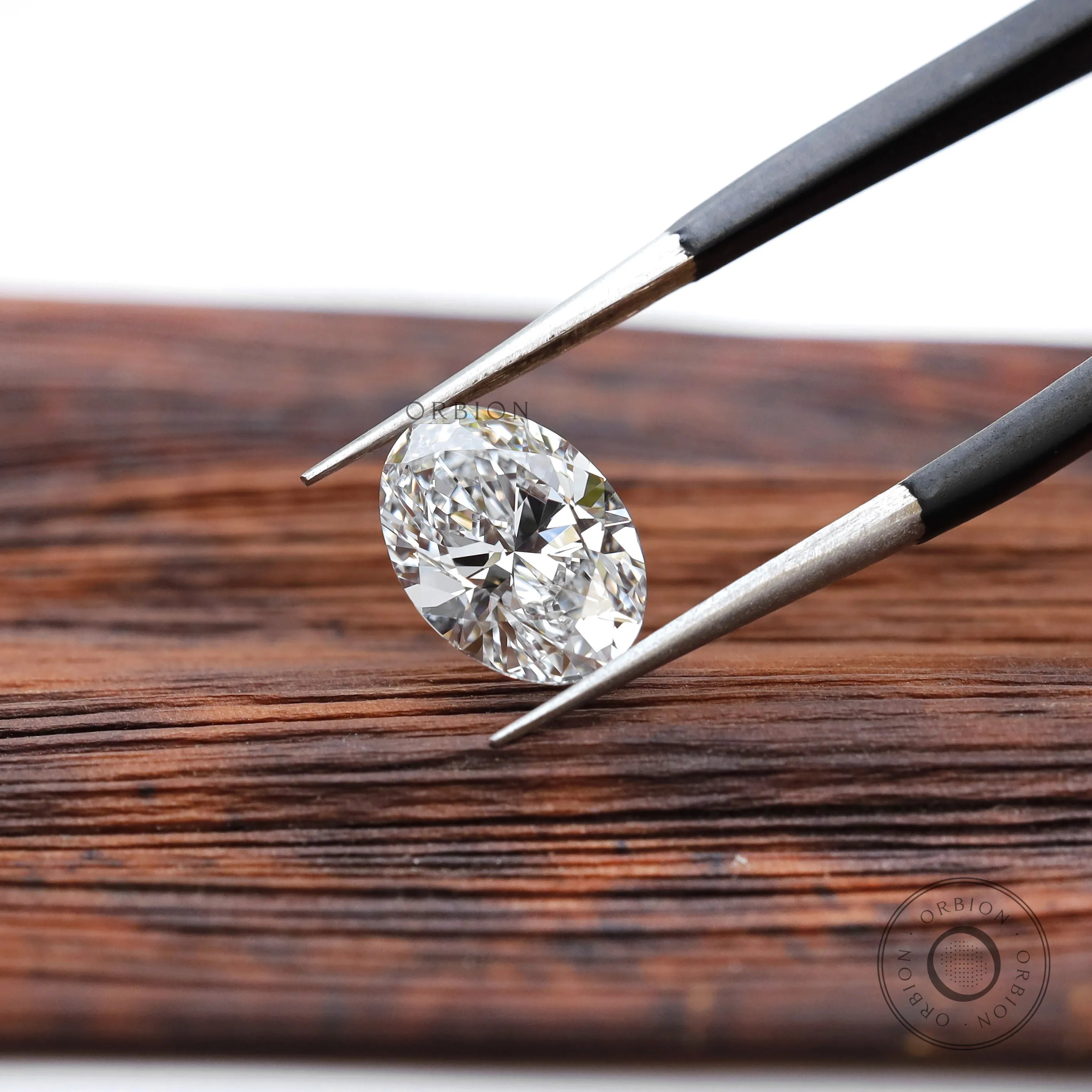 Loose oval brilliant lab diamond displayed over wooden surface
