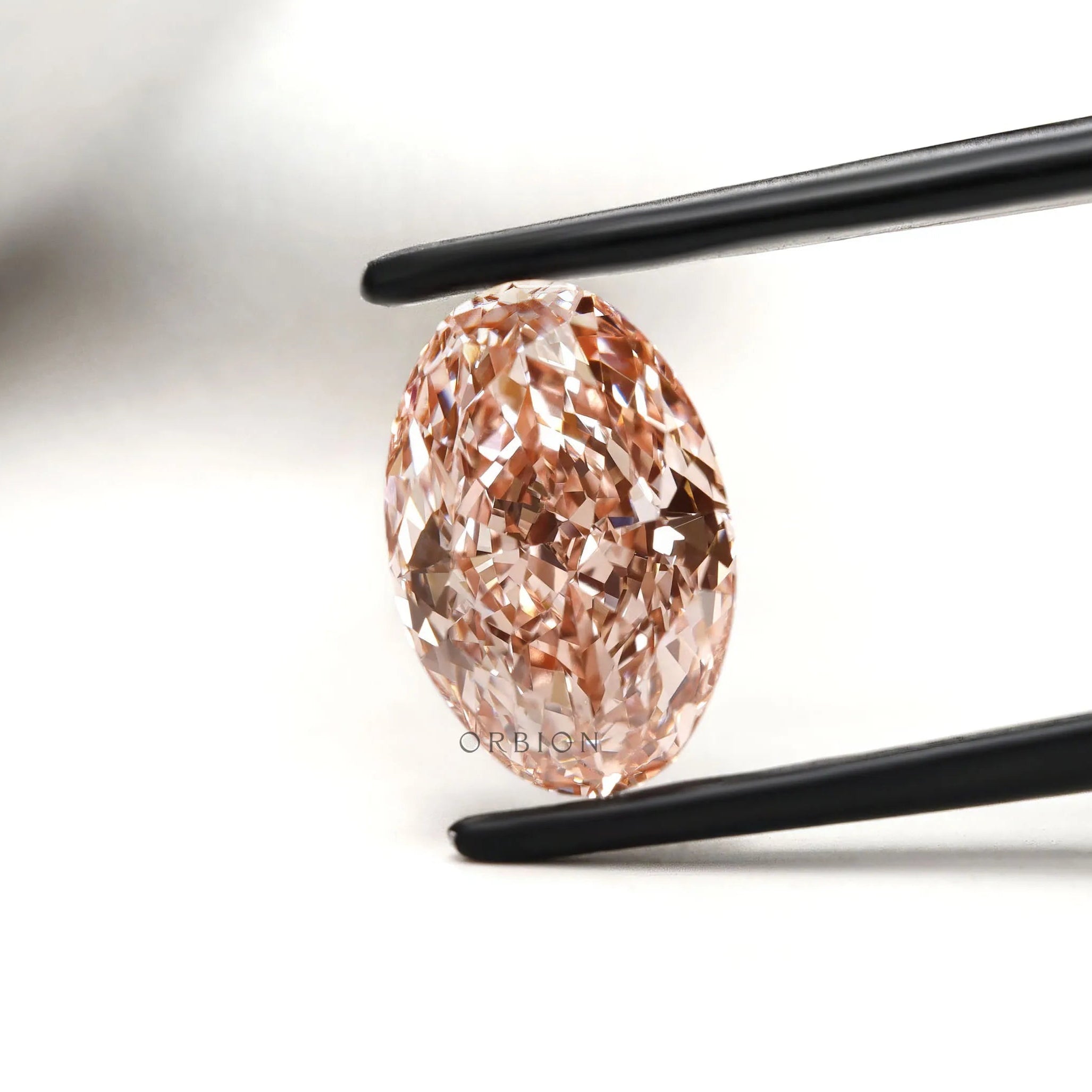 Oval pink lab diamond side angle showing brilliance and fire