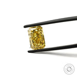 Bright yellow radiant lab diamond face up in tweezers