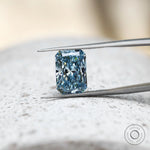 Radiant cut blue lab diamond shown upright in tweezers