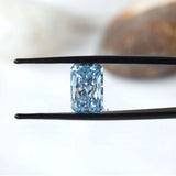 Fancy vivid blue radiant diamond held in black tweezers