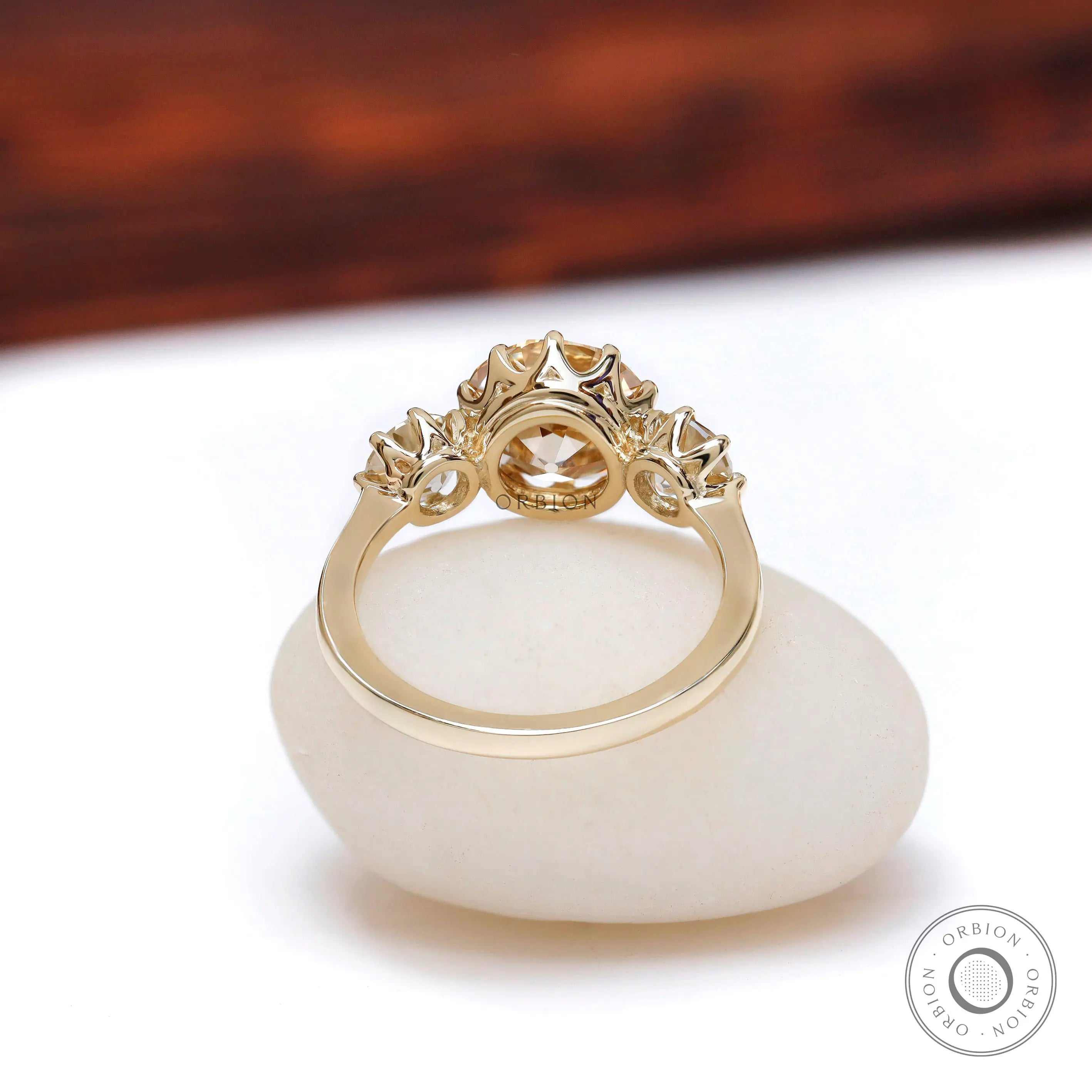 Back view three stone champagne moissanite ring yellow gold