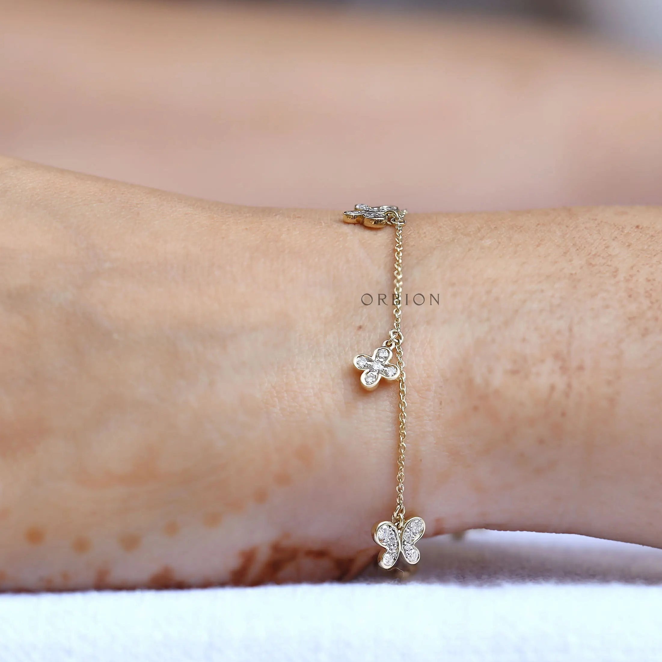 Worn top view minimal butterfly clover diamond bolo bracelet