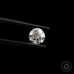 Front-facing round nova cut lab diamond held in black tweezers