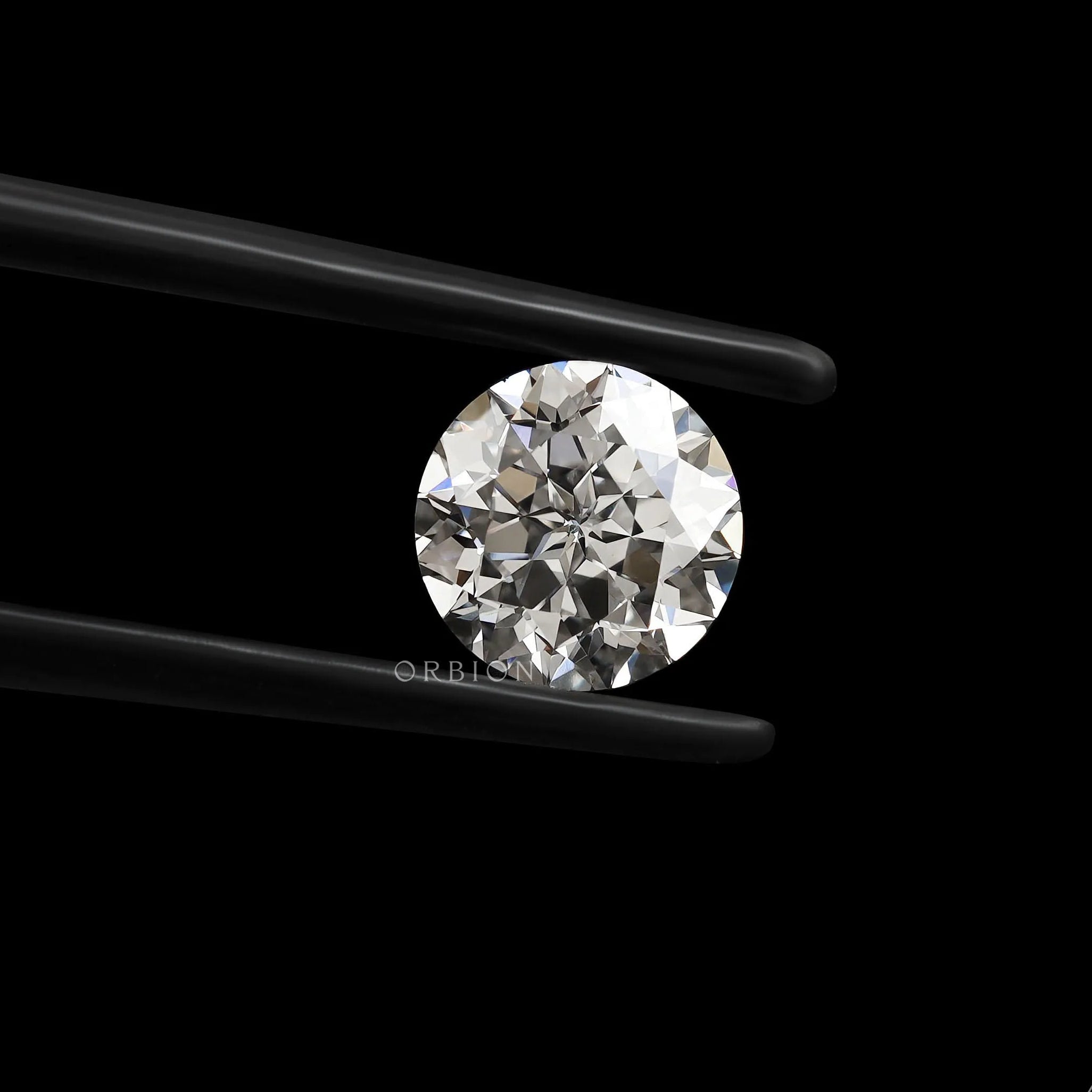 Front-facing round nova cut lab diamond held in black tweezers