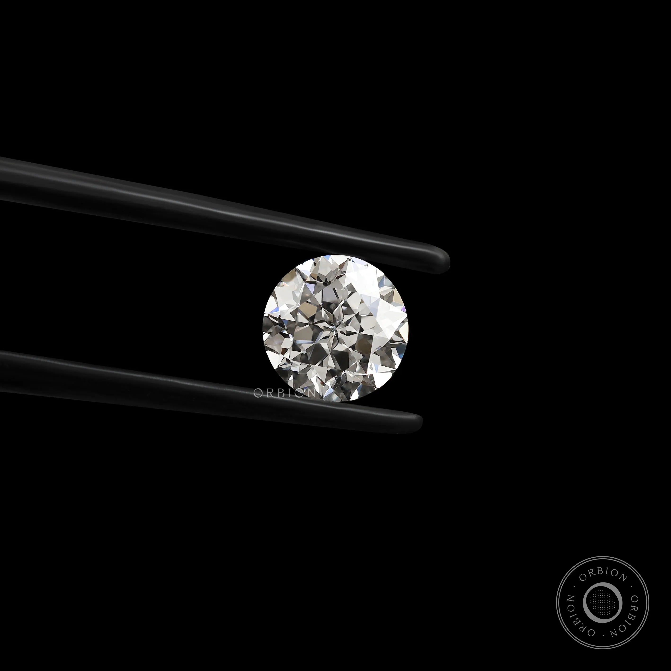 Front-facing round nova cut lab diamond held in black tweezers