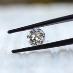 Round old cut moissanite displaying warm reflective brilliance