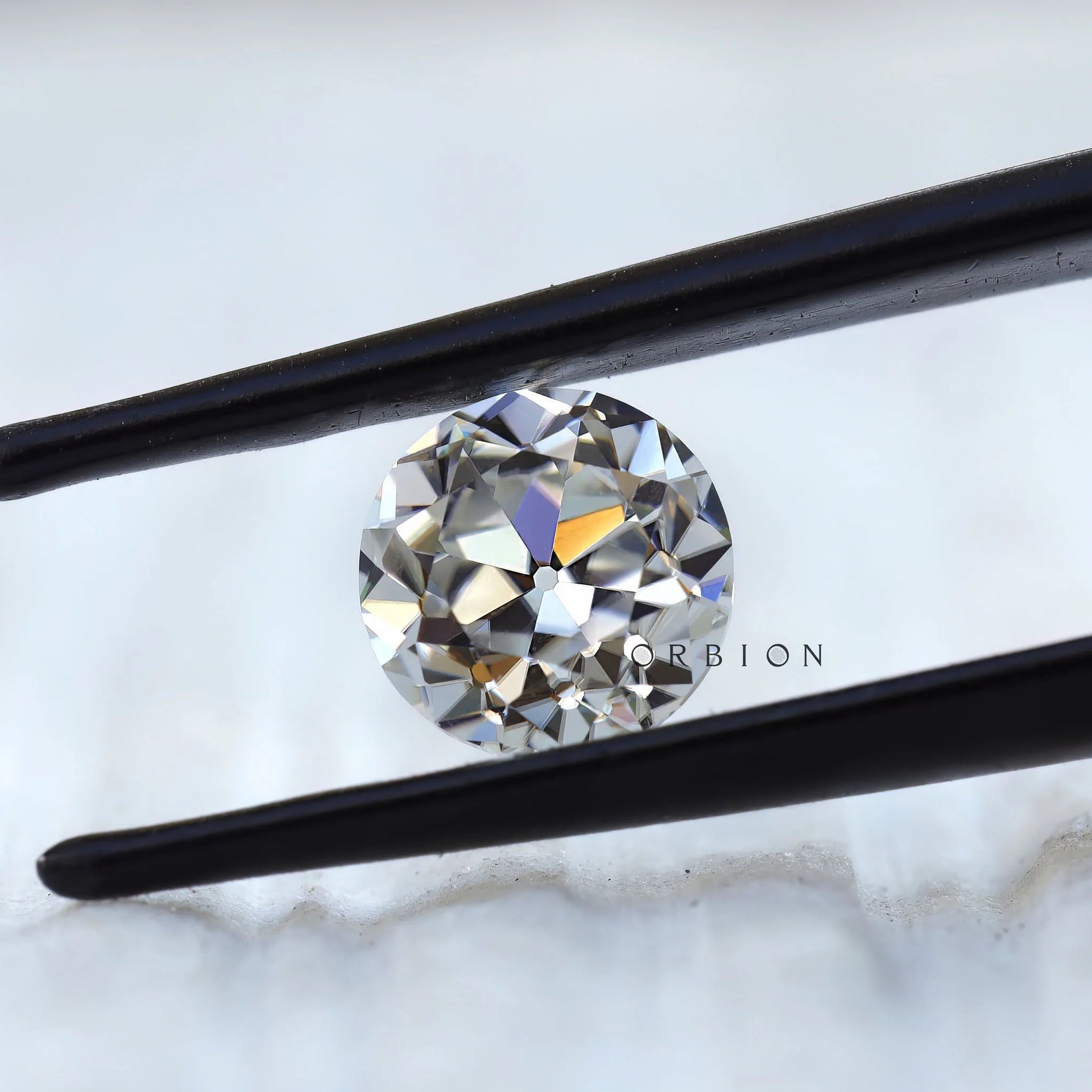 Round old cut moissanite displaying warm reflective brilliance
