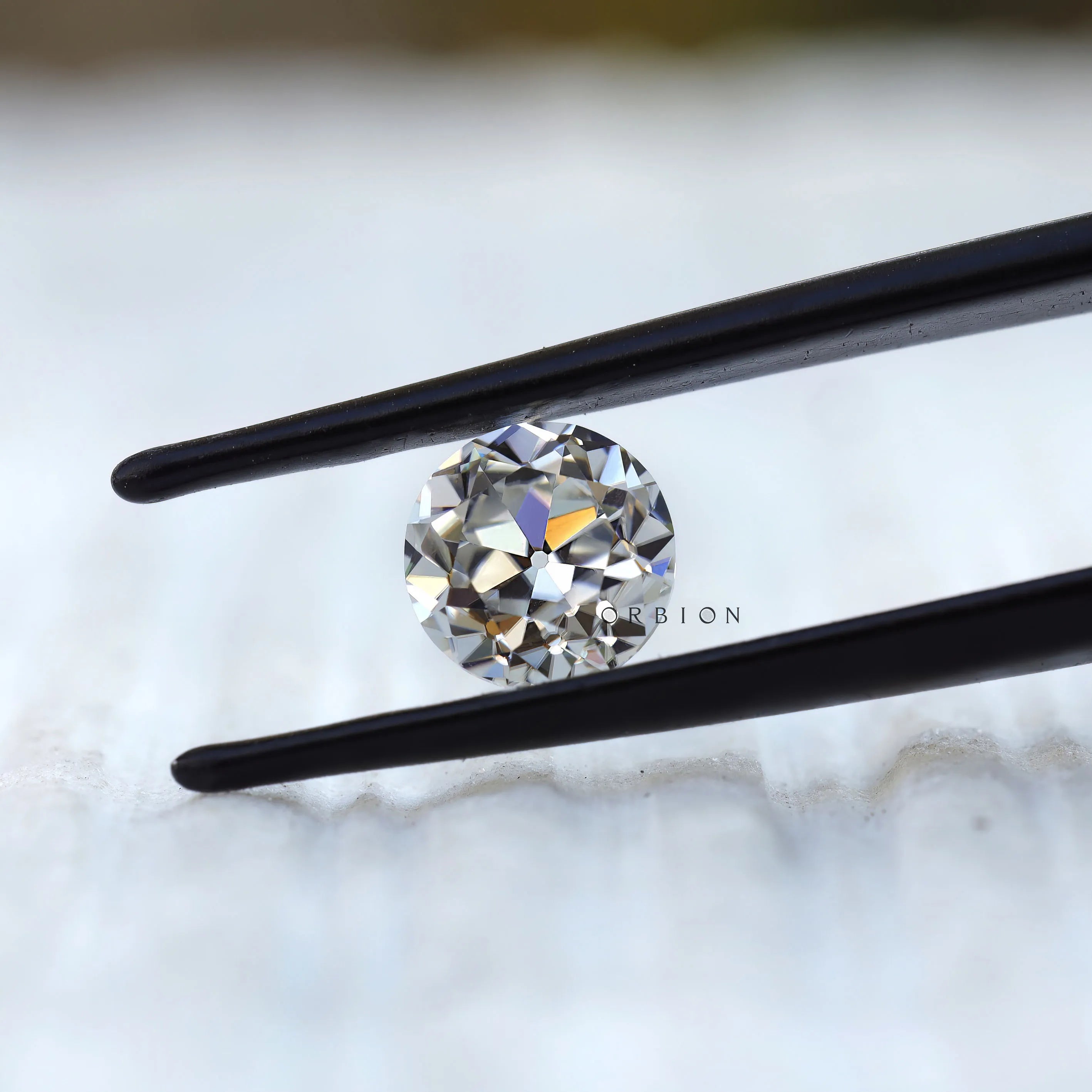 Round old cut moissanite displaying warm reflective brilliance