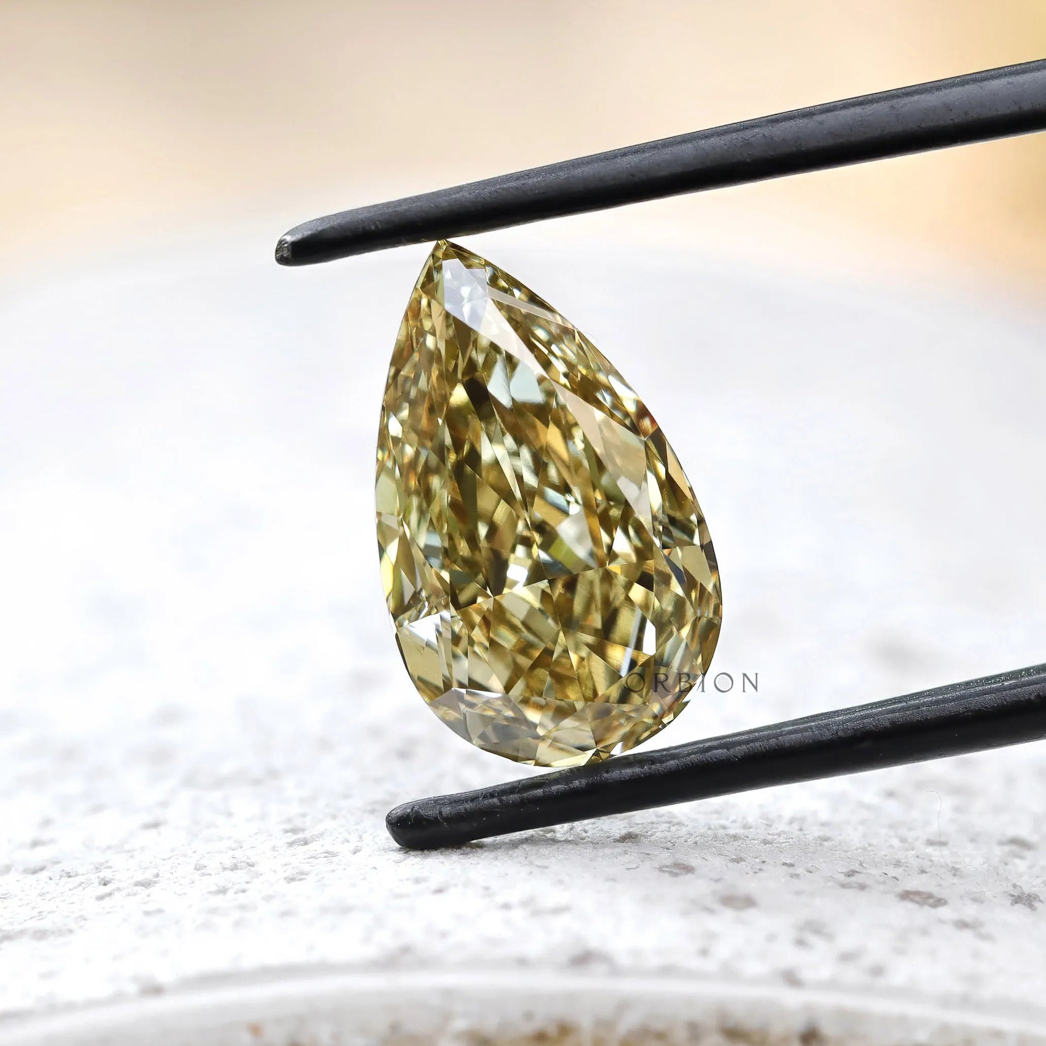 Close angled view of fancy yellow pear lab diamond