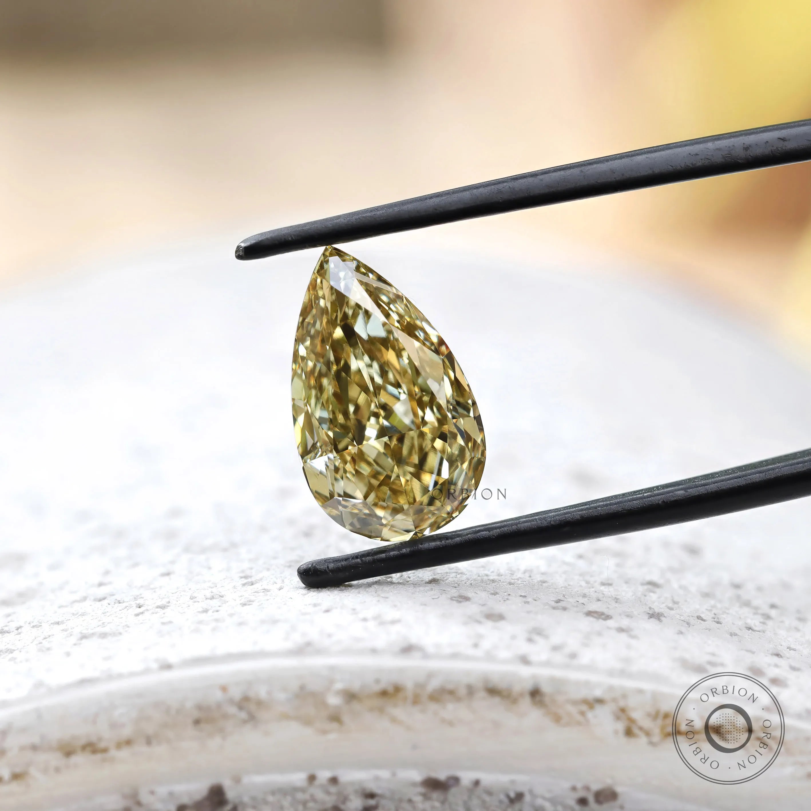 Close angled view of fancy yellow pear lab diamond