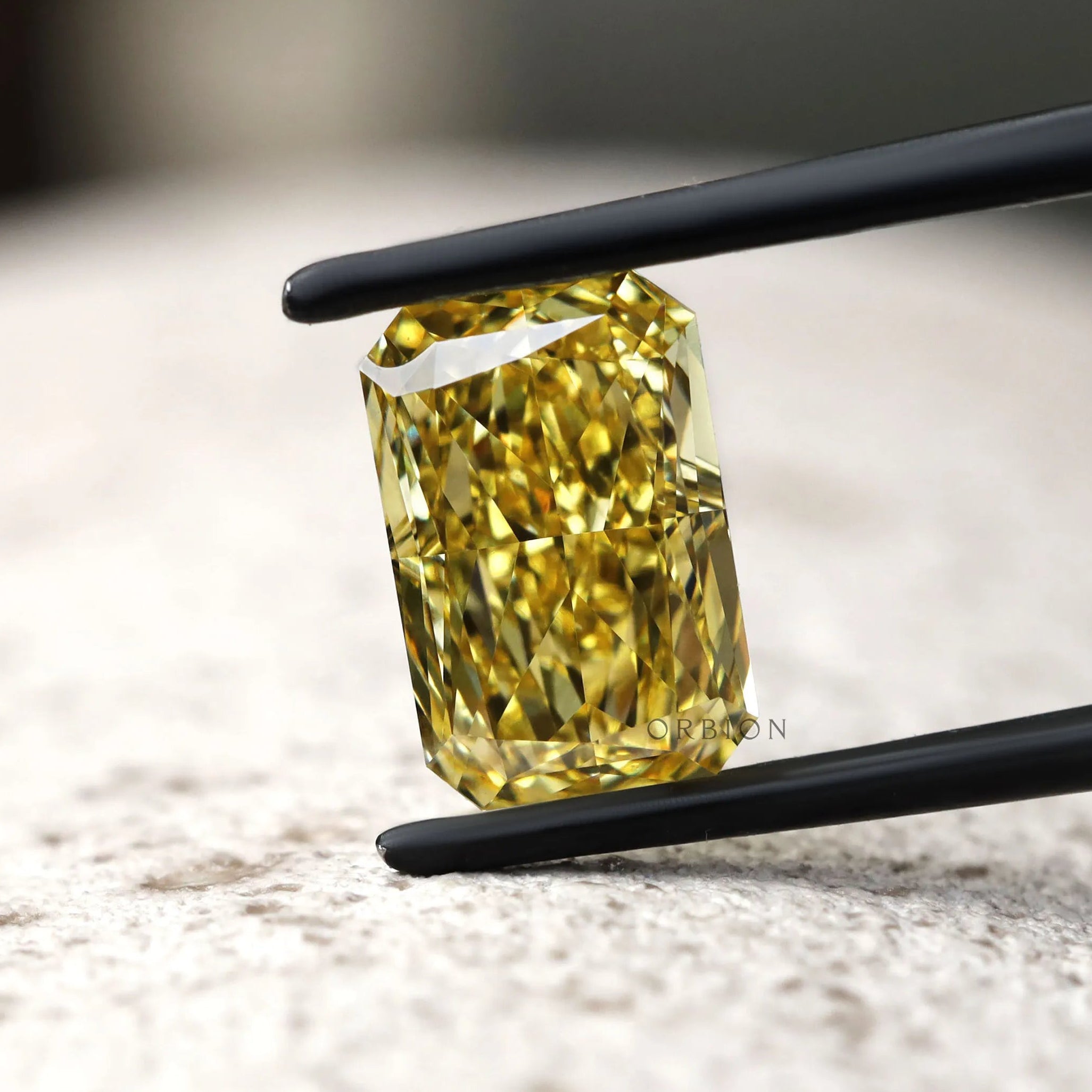 Fancy vivid yellow radiant diamond on textured surface
