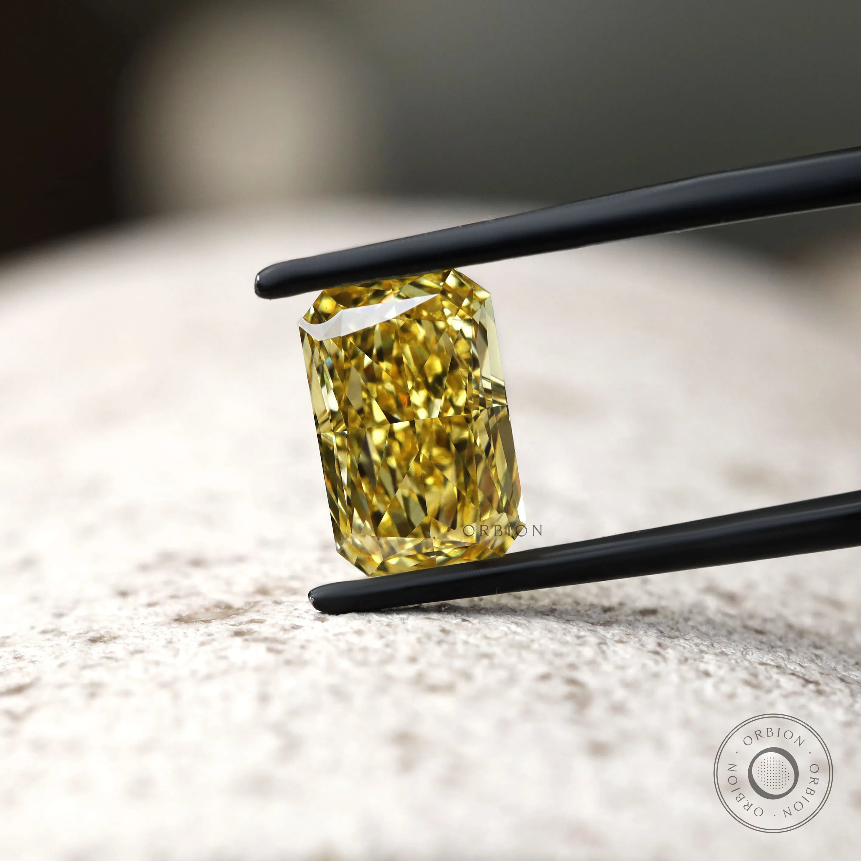 Fancy vivid yellow radiant diamond on textured surface