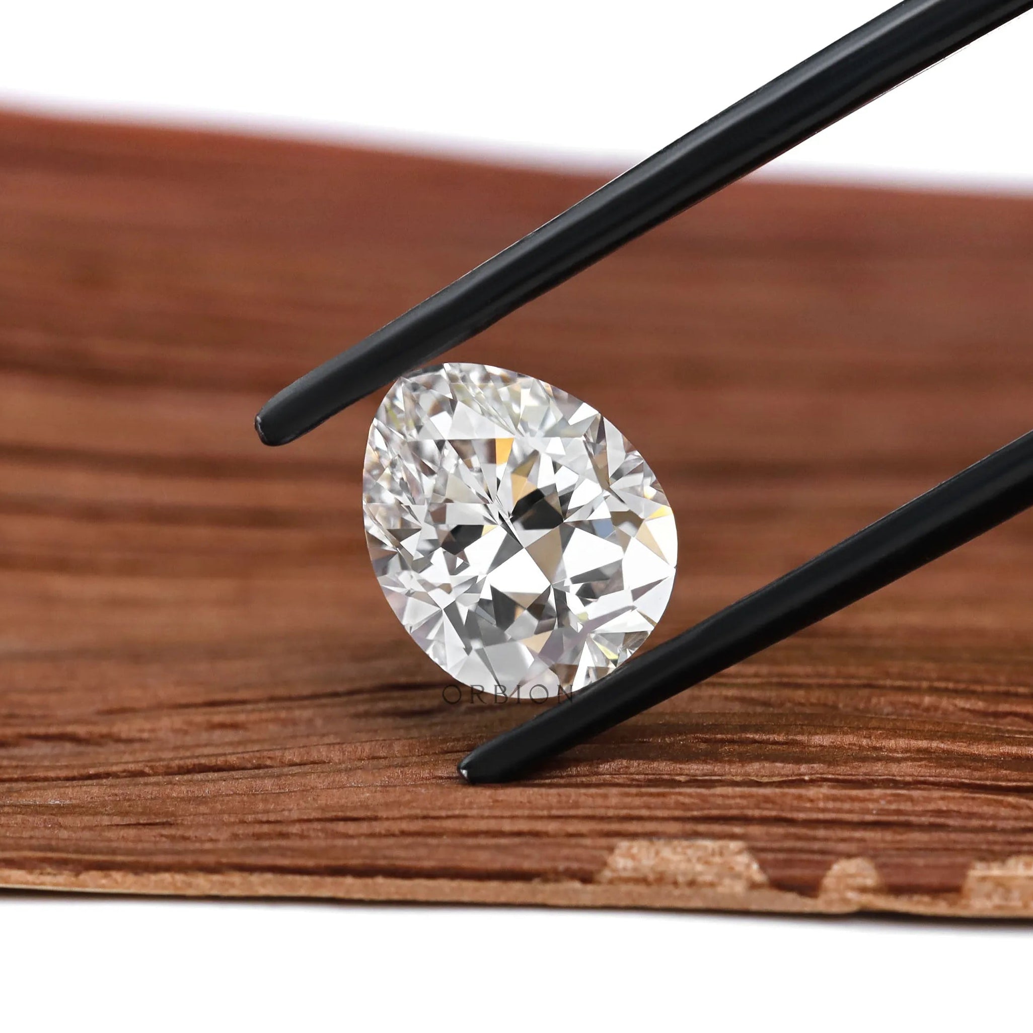 Pear brilliant cut loose diamond shown on neutral stone surface