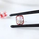 Back view of fancy vivid pink cushion diamond in tweezers