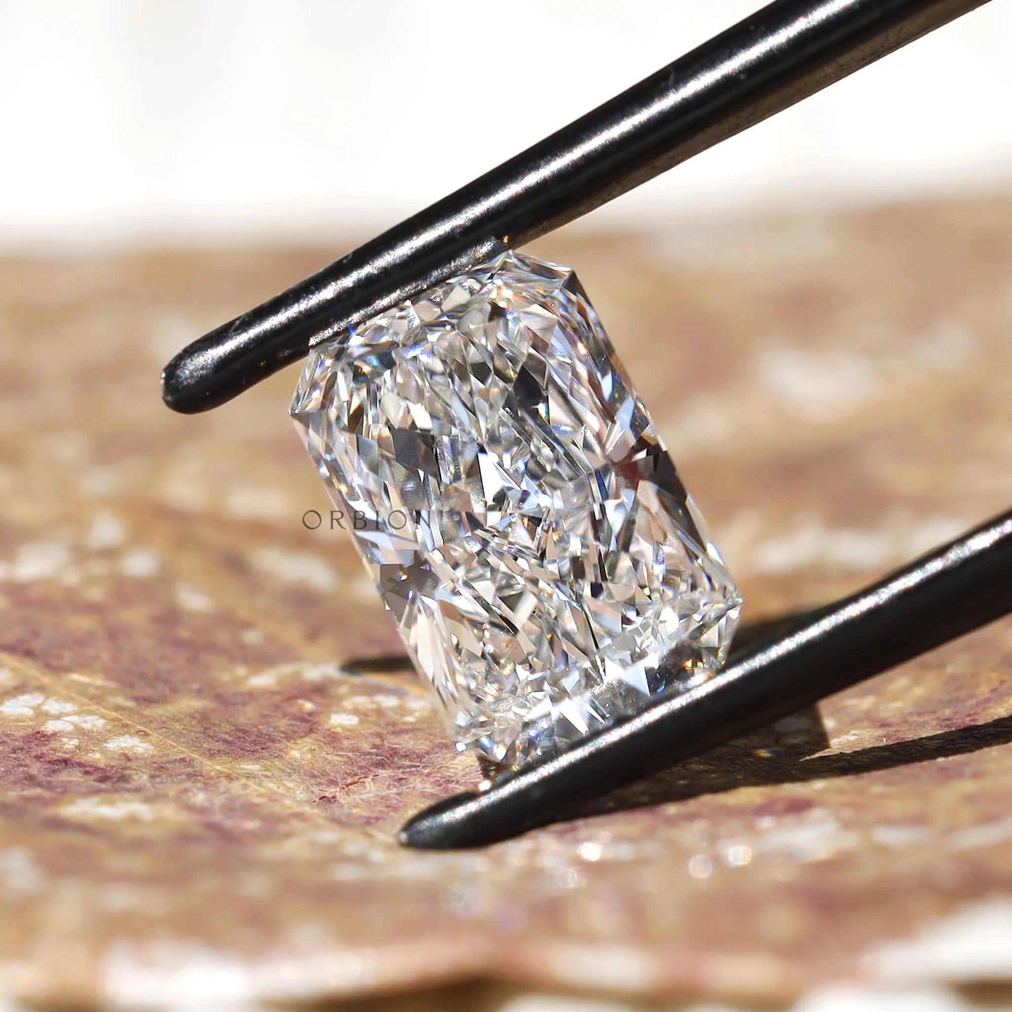 Side angled radiant cut lab diamond on textured surface