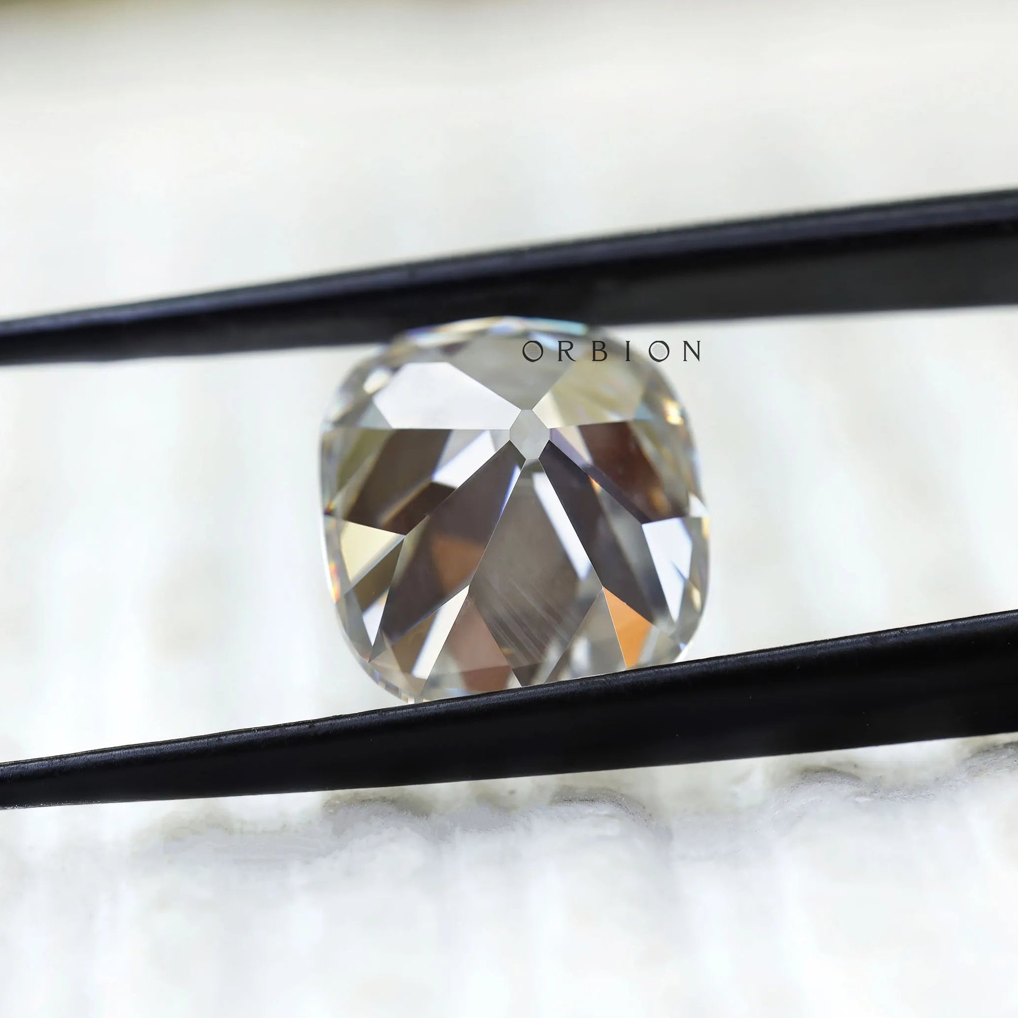 Vintage style cushion moissanite showing broad chunky faceting