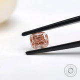 Side angled fancy pink elongated cushion diamond in tweezers