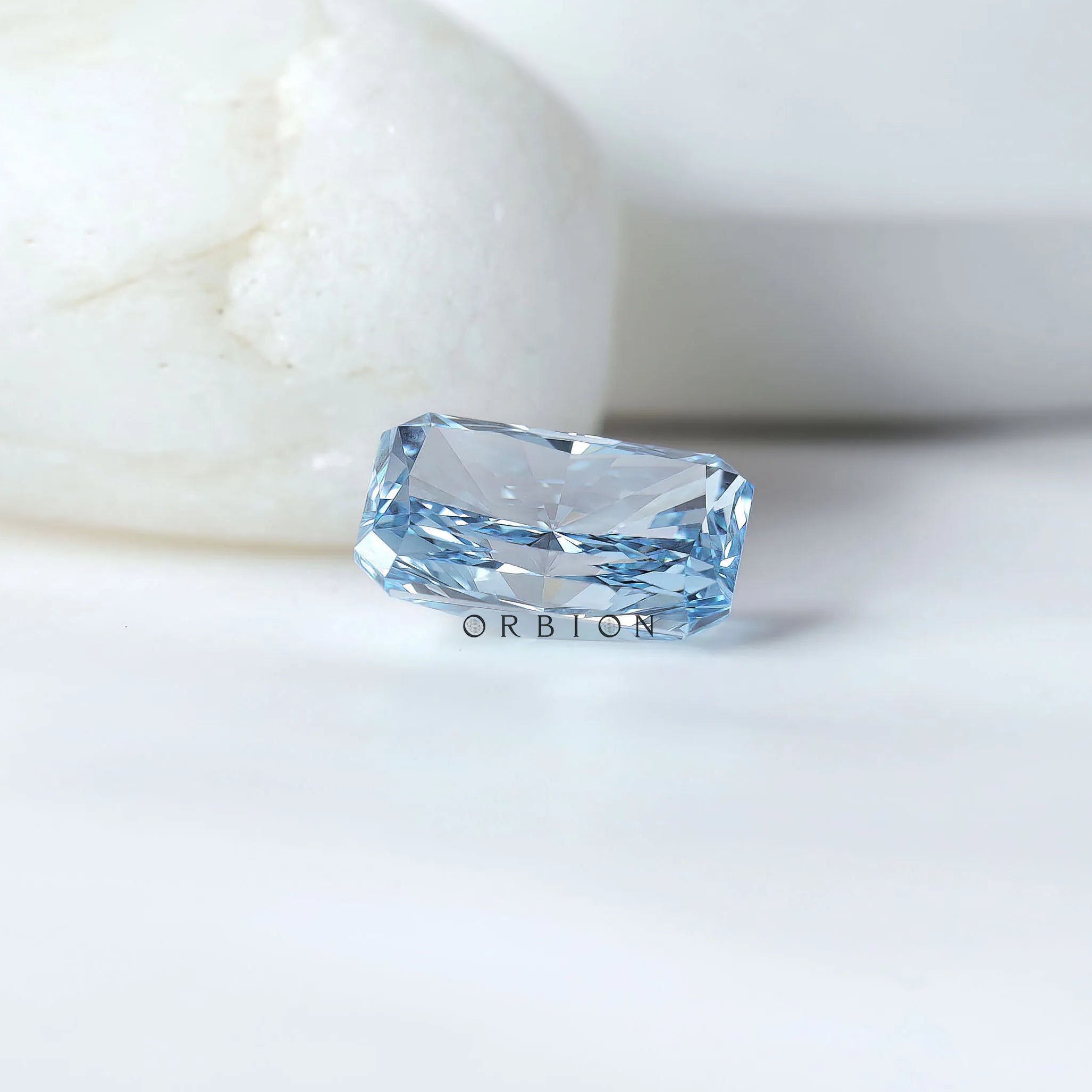 Blue radiant cut lab diamond beside neutral display stones