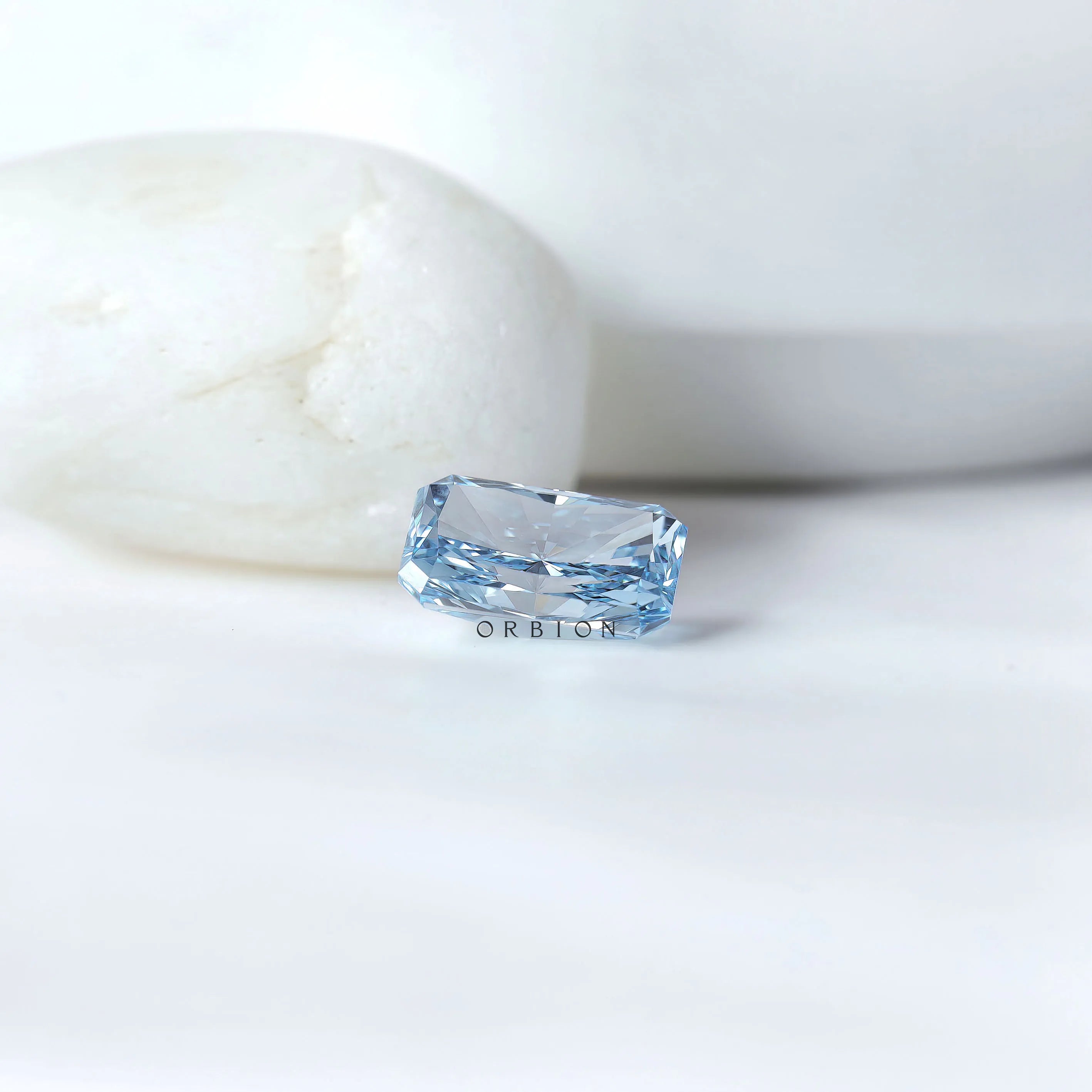 Blue radiant cut lab diamond beside neutral display stones