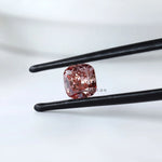 Soft square cushion pink lab diamond held in tweezers
