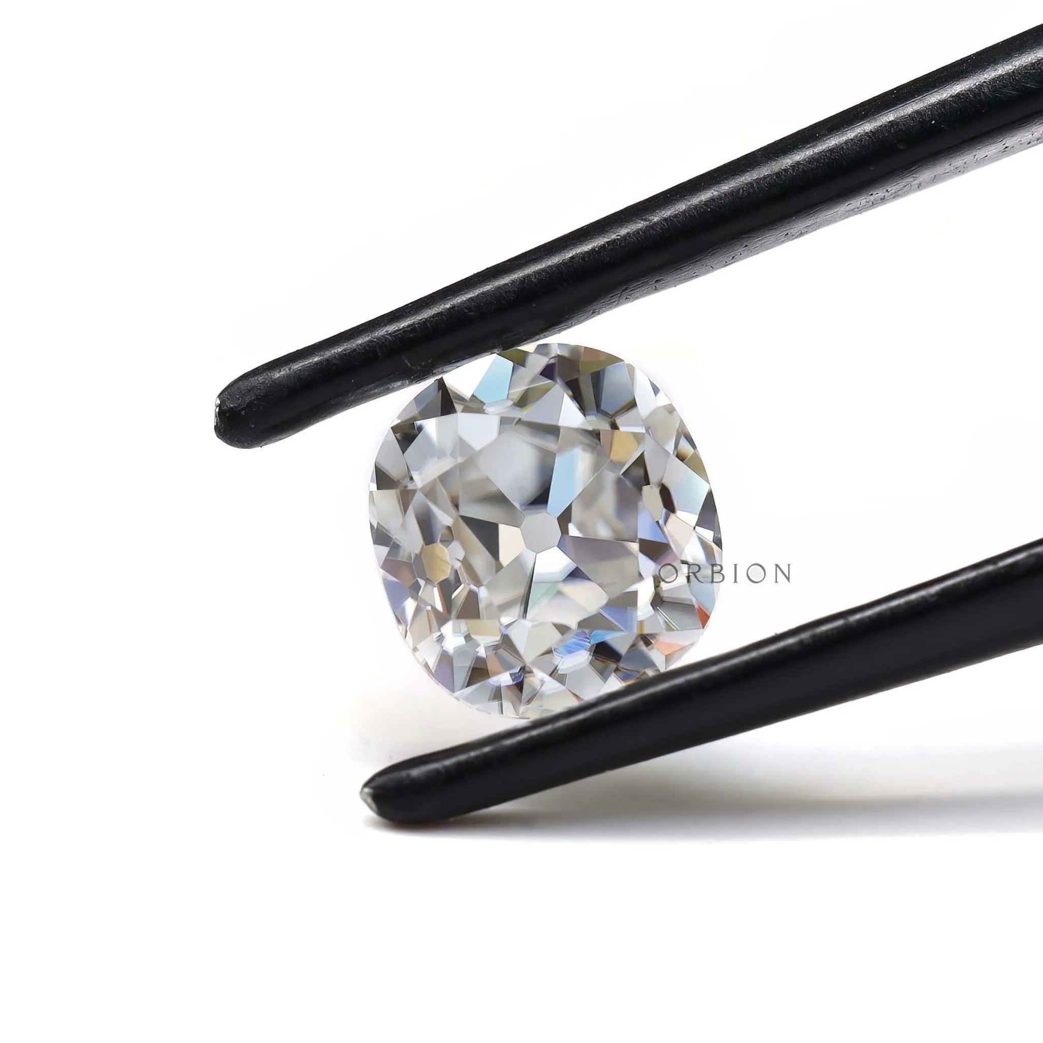Front view DEF elongated cushion loose moissanite in tweezers