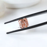 Fancy vivid pink radiant diamond held between black tweezers