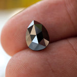 Rose cut black pear moissanite stone under sunlight