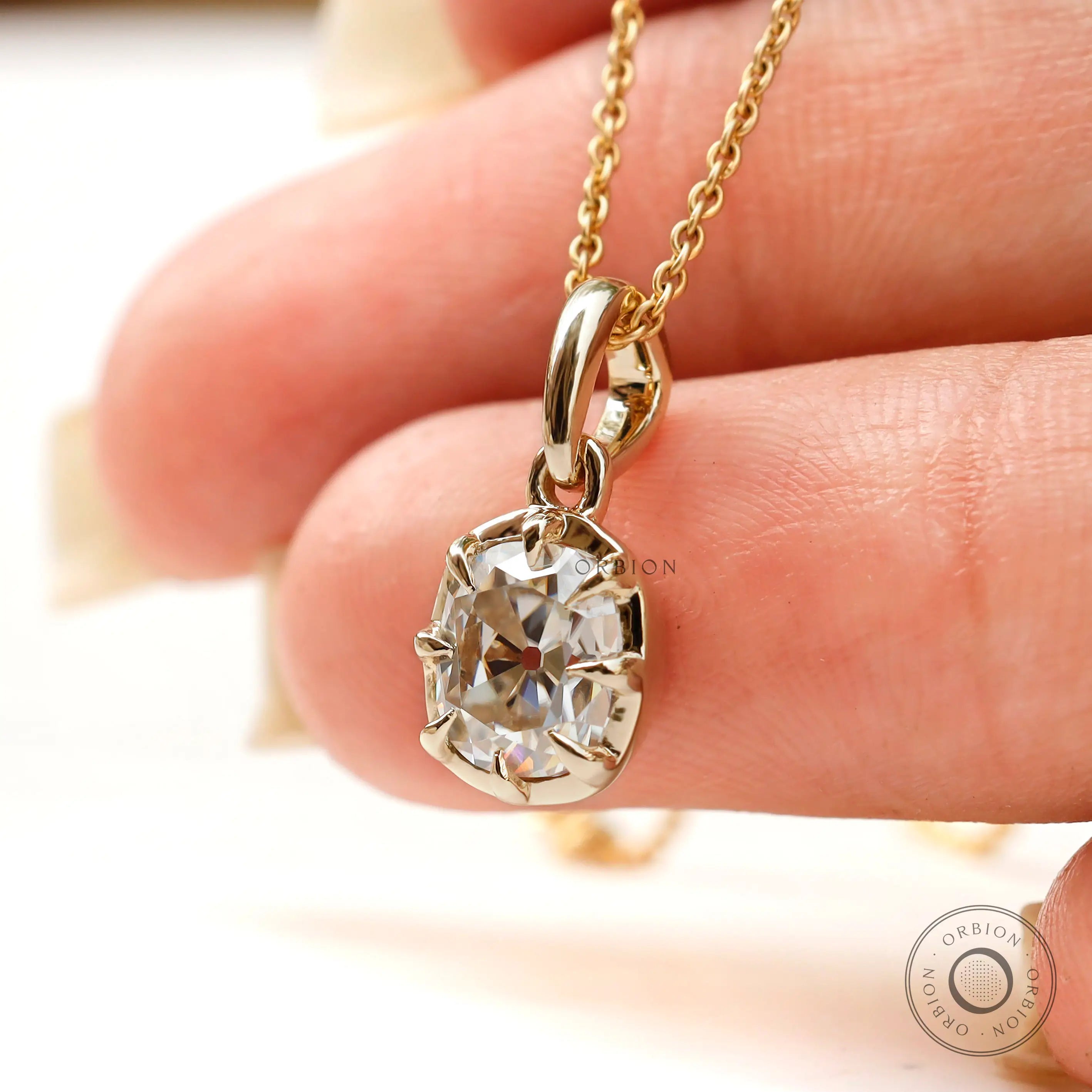 Close up Georgian old mine moissanite pendant held in hand