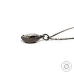 Low side view of pear moissanite pendant on chain