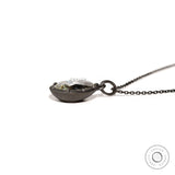Low side view of pear moissanite pendant on chain