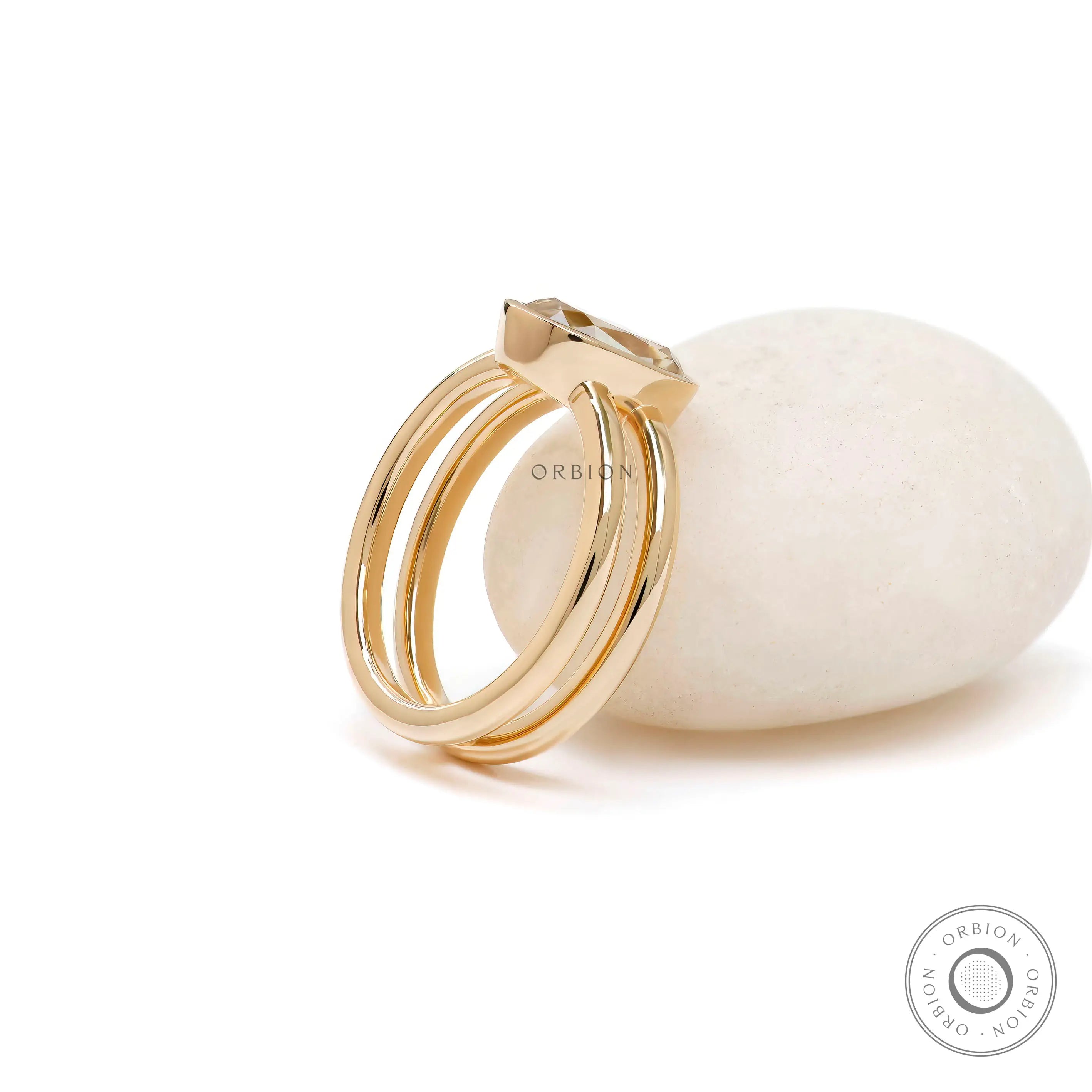 Angled view elongated cushion champagne moissanite bezel ring gold