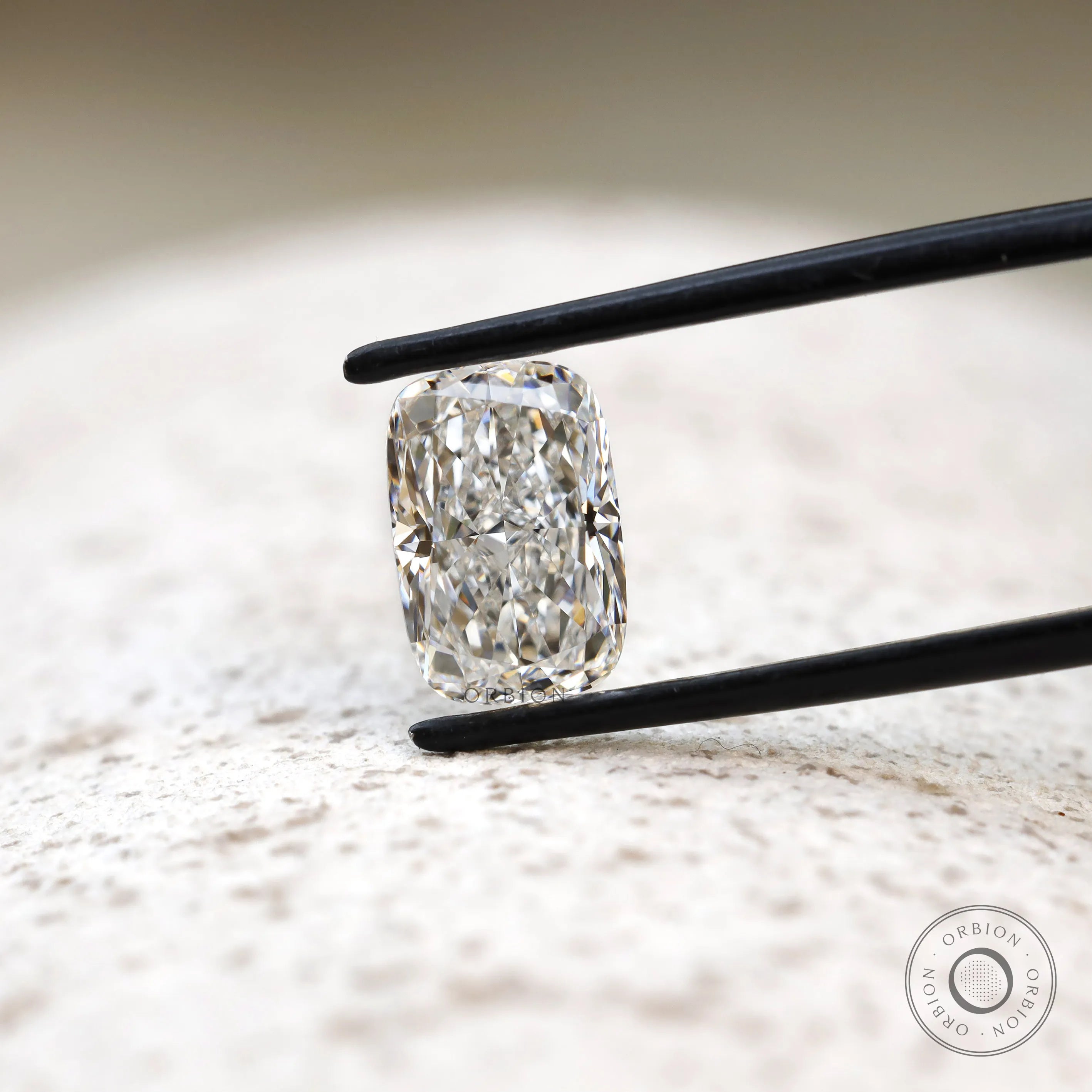 Centered elongated cushion crushed ice lab diamond in tweezers