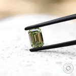 Fancy green emerald lab diamond on white surface
