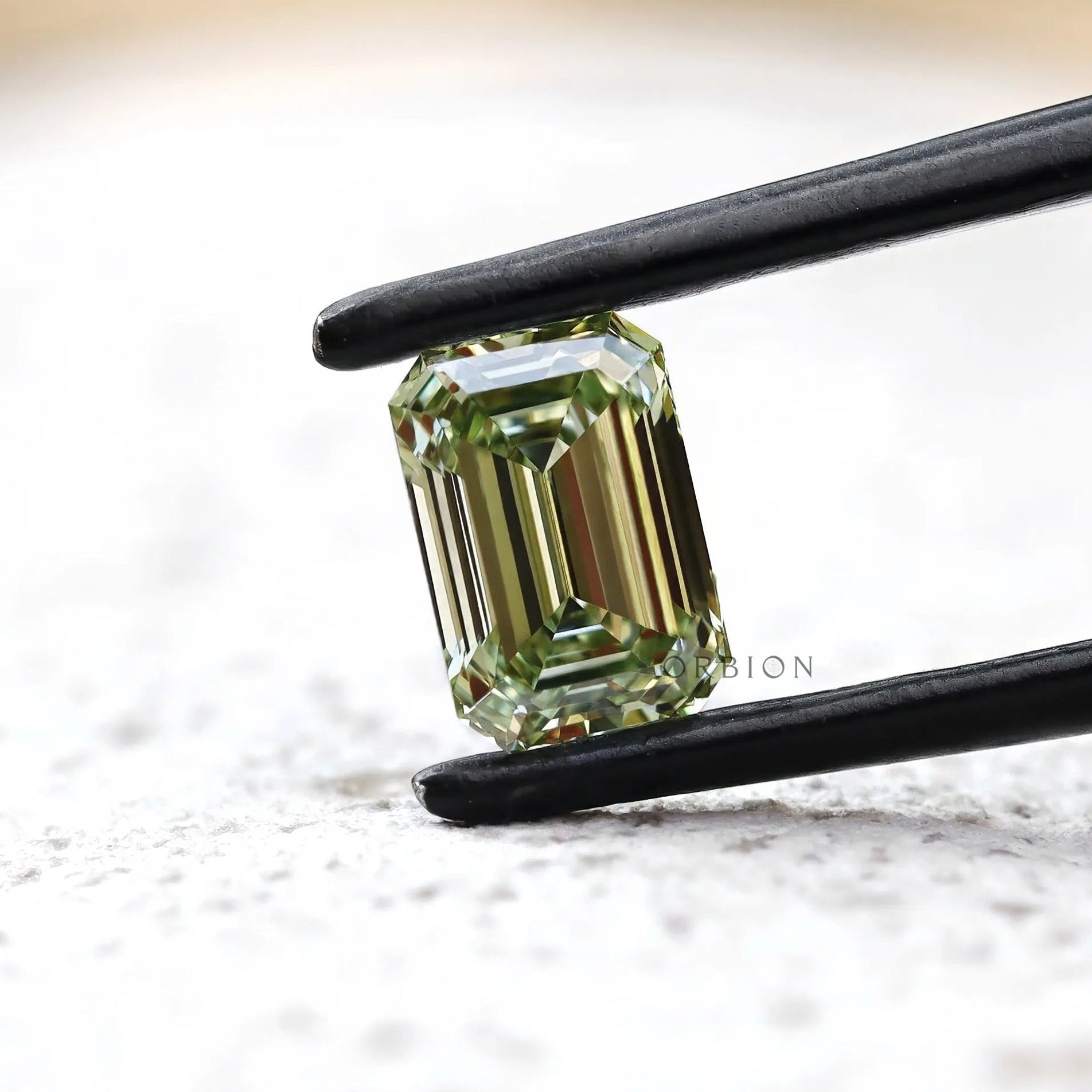 Fancy green emerald lab diamond on white surface