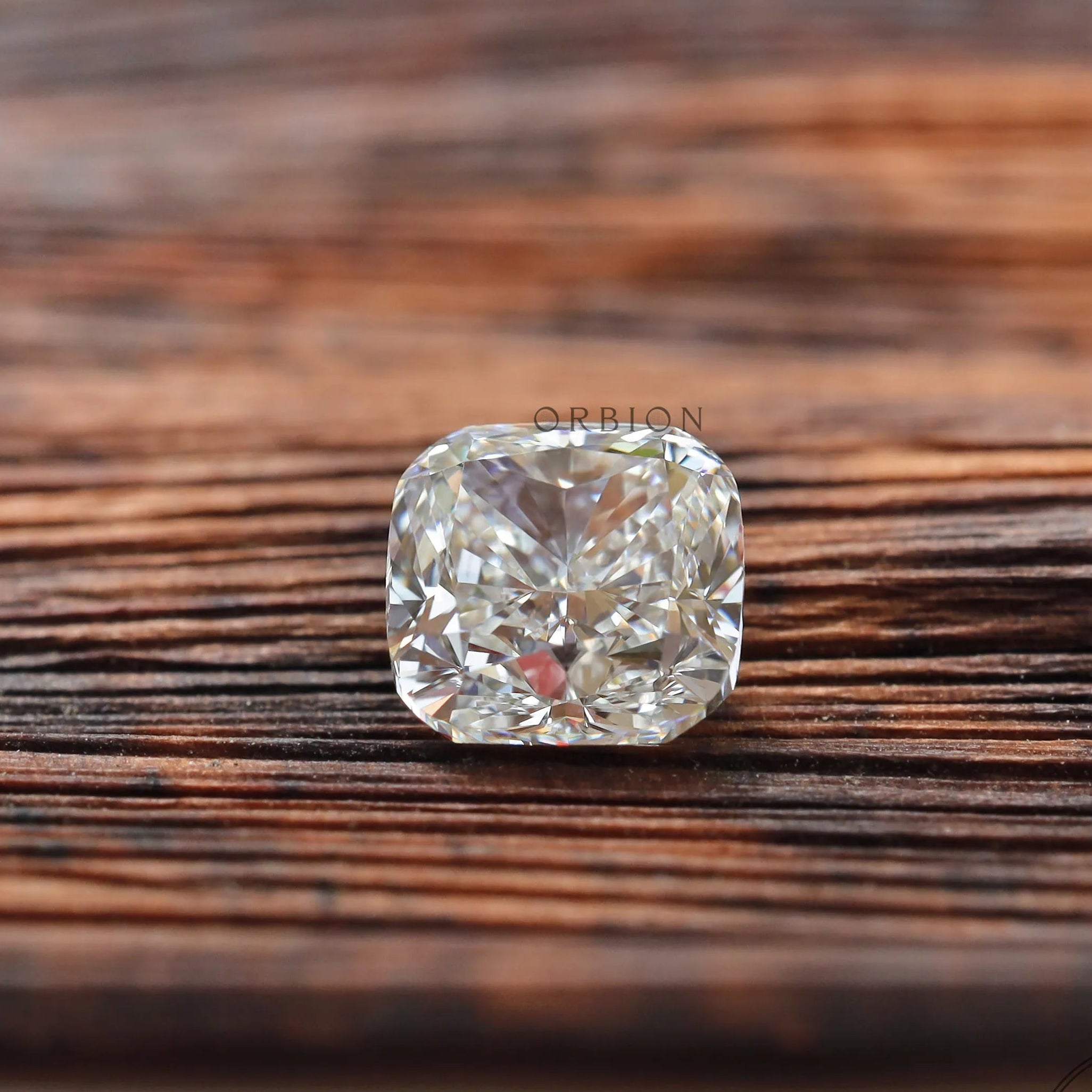 Face-up cushion loose lab diamond on wooden background