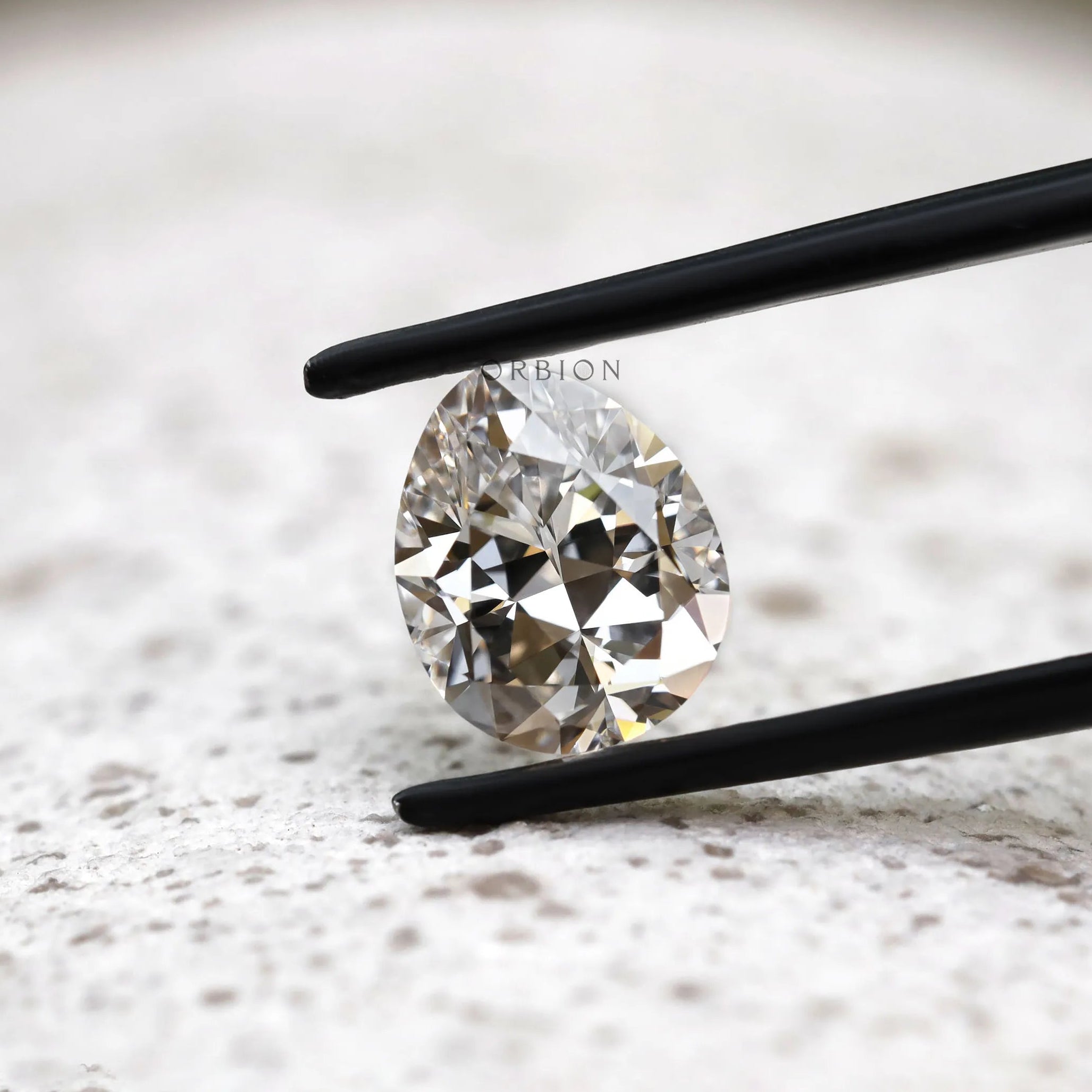 DEF pear lab diamond in tweezers with crisp faceting