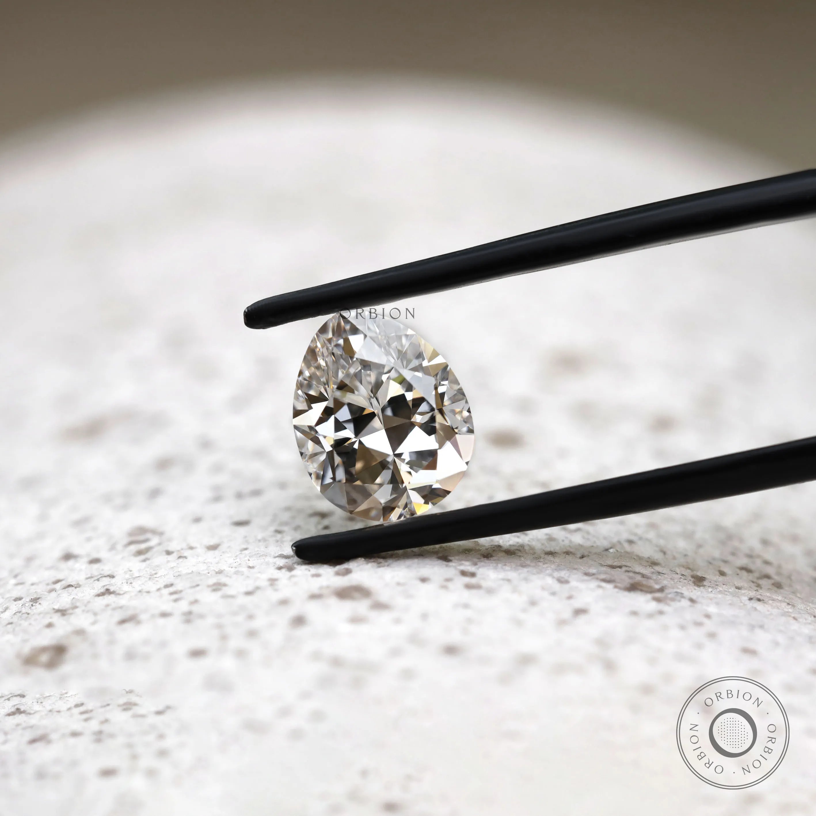 DEF pear lab diamond in tweezers with crisp faceting