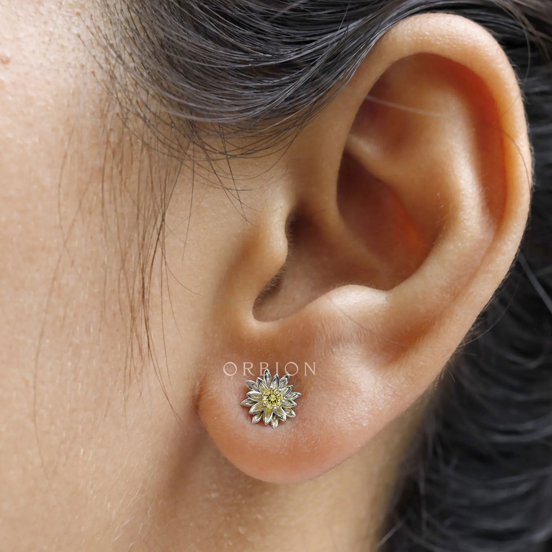 Elegant lotus flower stud earrings with yellow diamond in white gold.