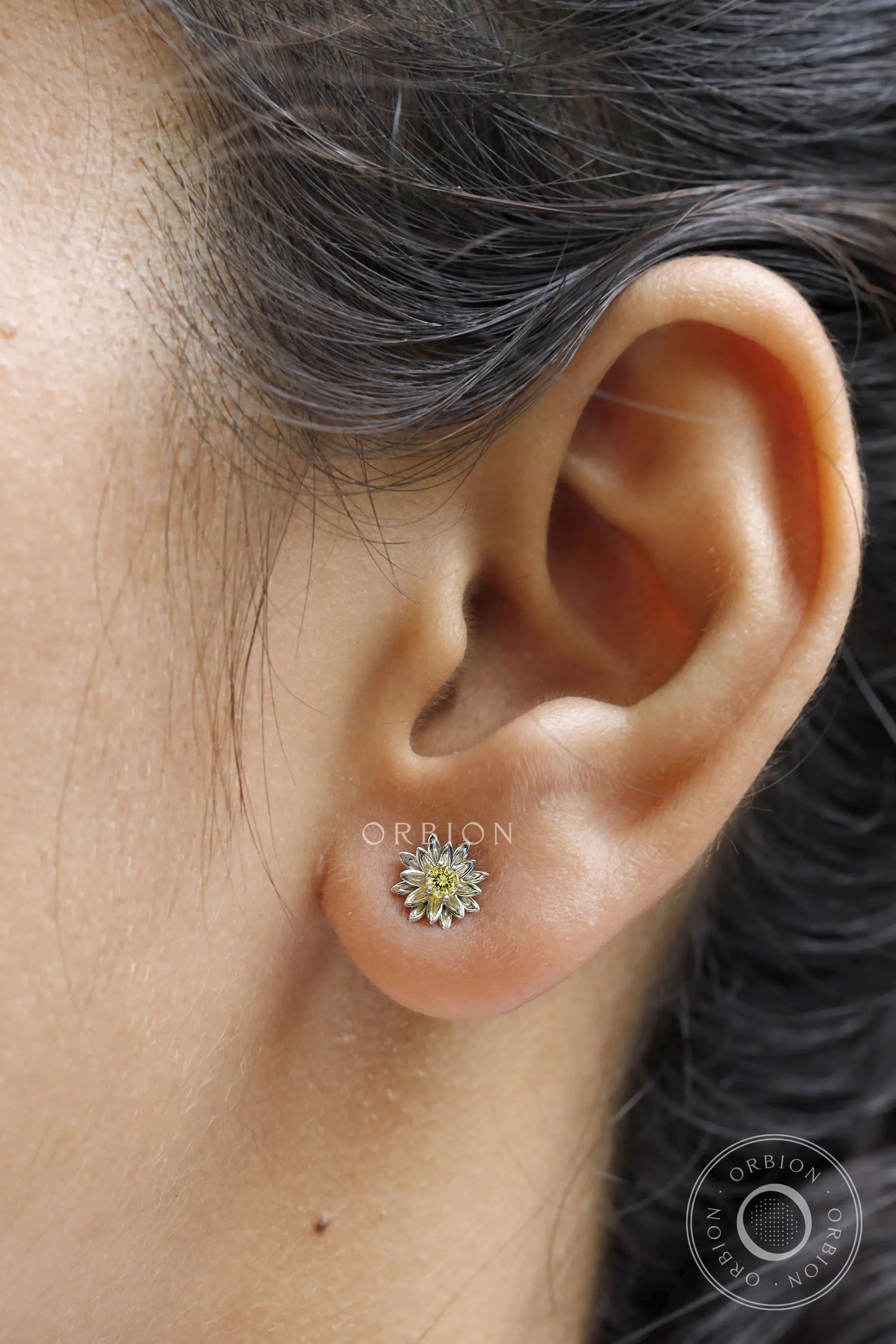 Elegant lotus flower stud earrings with yellow diamond in white gold.