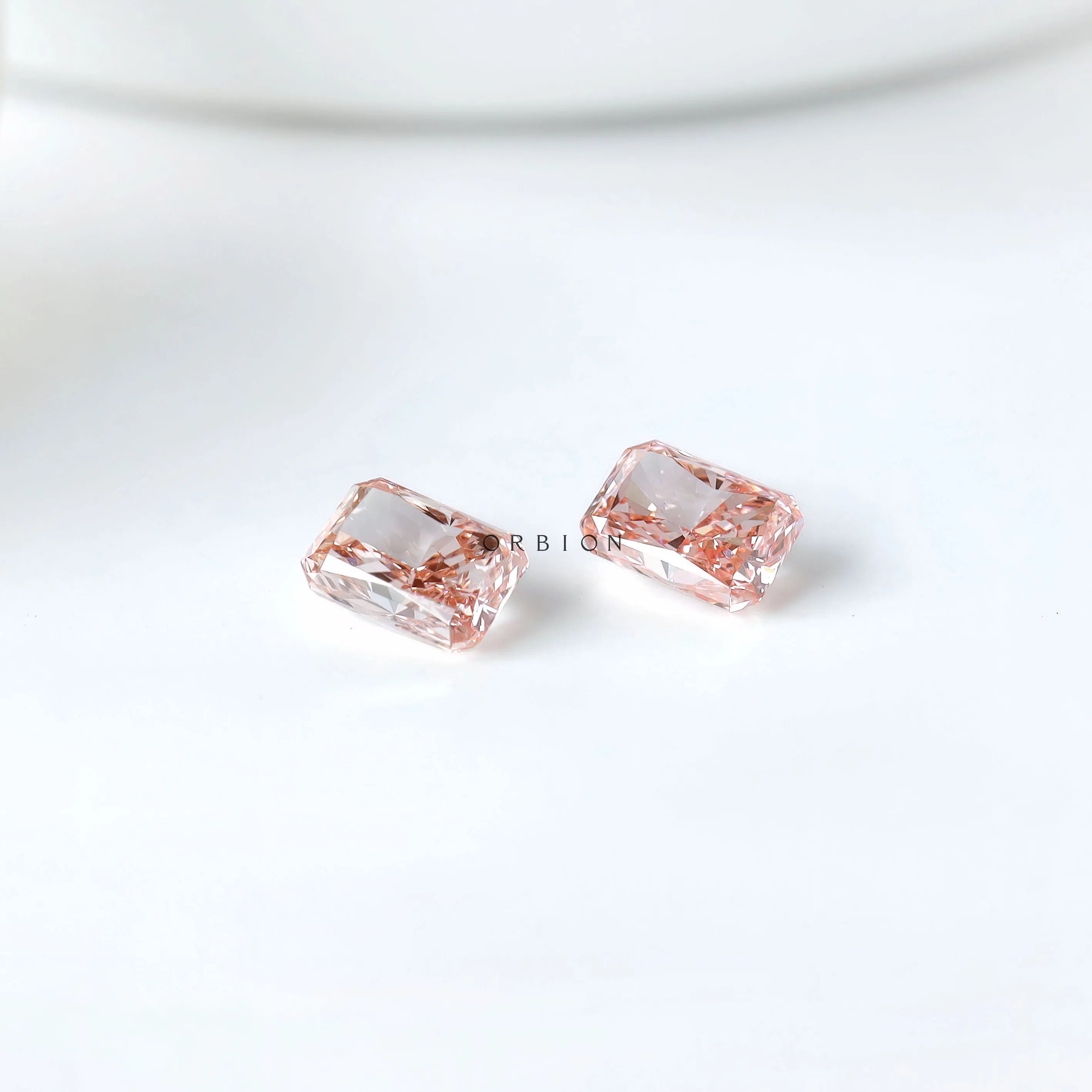 Two radiant pink lab diamonds shown pavilion side