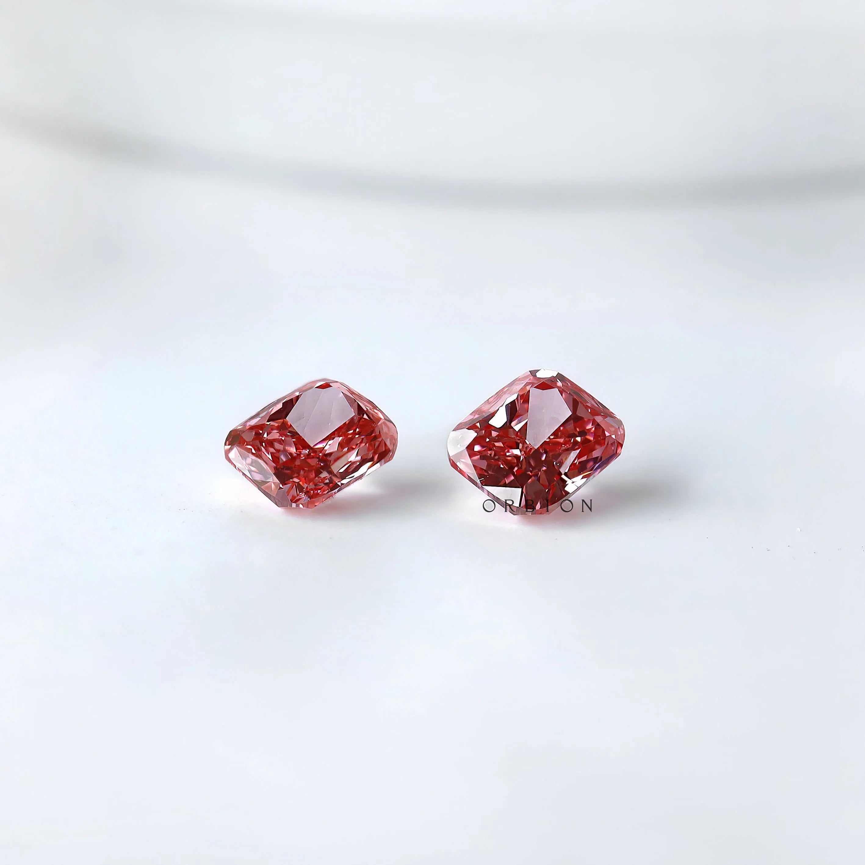 Two fancy vivid pink cushion lab diamonds side by side